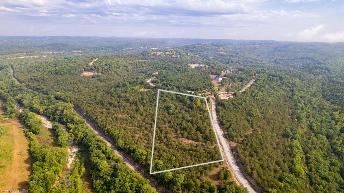 Private upscale, gated community in a great location. This 5+ acre m/l parcel offers prime location to Branson, great building spot and amazing views of the Ozark Mountains and Shepherd of the Hills. Come build your dream home in Mills Hollow!