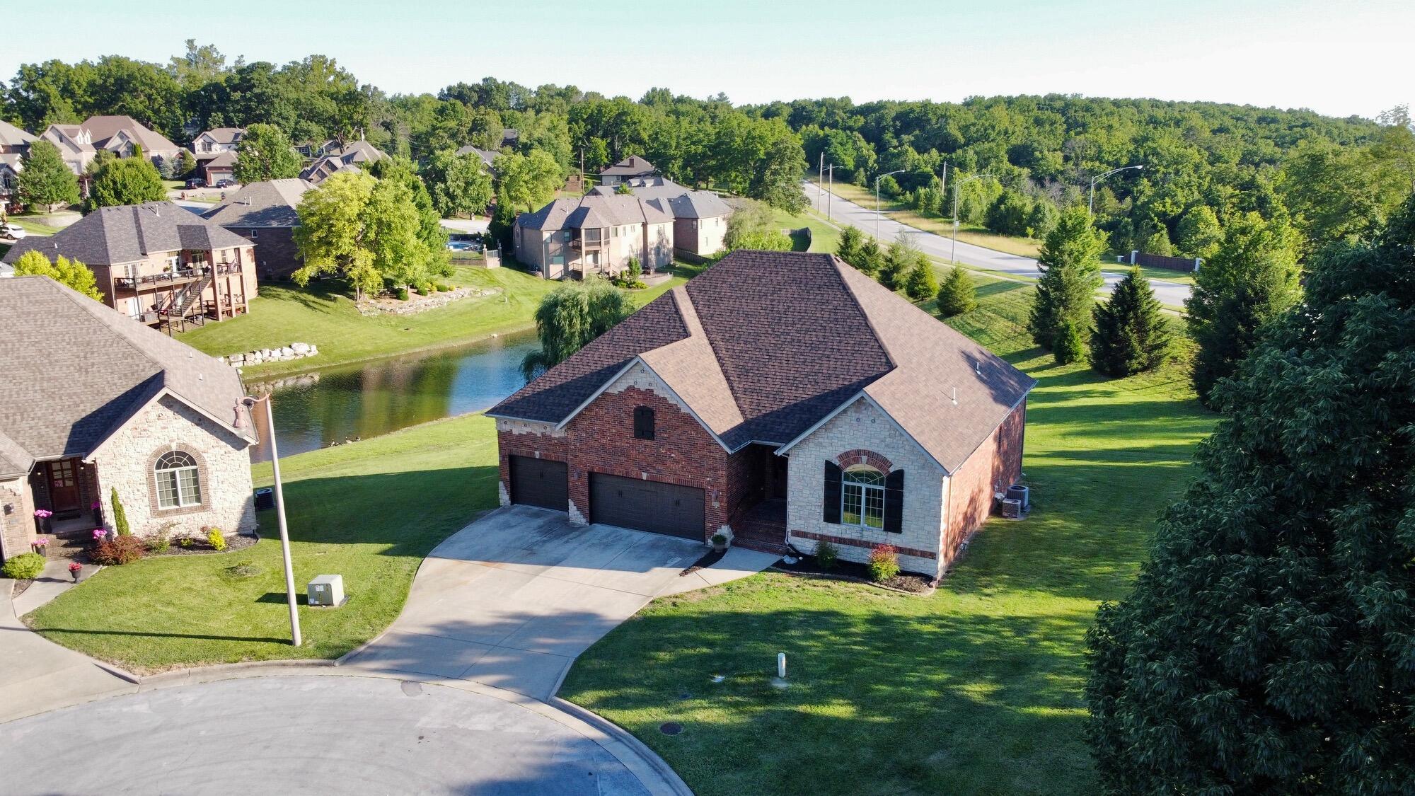 This wonderful home backs up to the Eaglegate subdivision lake! The covered deck allows you to enjoy the view while entertaining from your walk out basement. This brick home  with a 3 car garage provides an abundance of space. 4 bedrooms (1 is non conforming with a closet but no window.) The primary suite is upstairs with an updated bath, including a walk in shower, soaking tub and walk in closet. The large entry way show cases a view of large windows, one of the fireplaces, new Mohawk Maple flooring with an updated railing on the steps to the fully finished basement. The open concept living/kitchen/dining area features quartz countertops, new appliances, a pantry, an eat at bar, along with a dining area. The cabinets are a great 2 color scheme. Access to the deck is from the this area. From the garage you enter a very large laundry room with plenty of storage. Downstairs you will find another fireplace, a large kitchen/wet bar area, living area and 2 of the bedrooms  The roof is approx. 5 years old, the water heater (approx. 2  years old) has on demand hot water and zoned HVAC. Subdivision offers pool & tennis courts. Make plans to see this one!