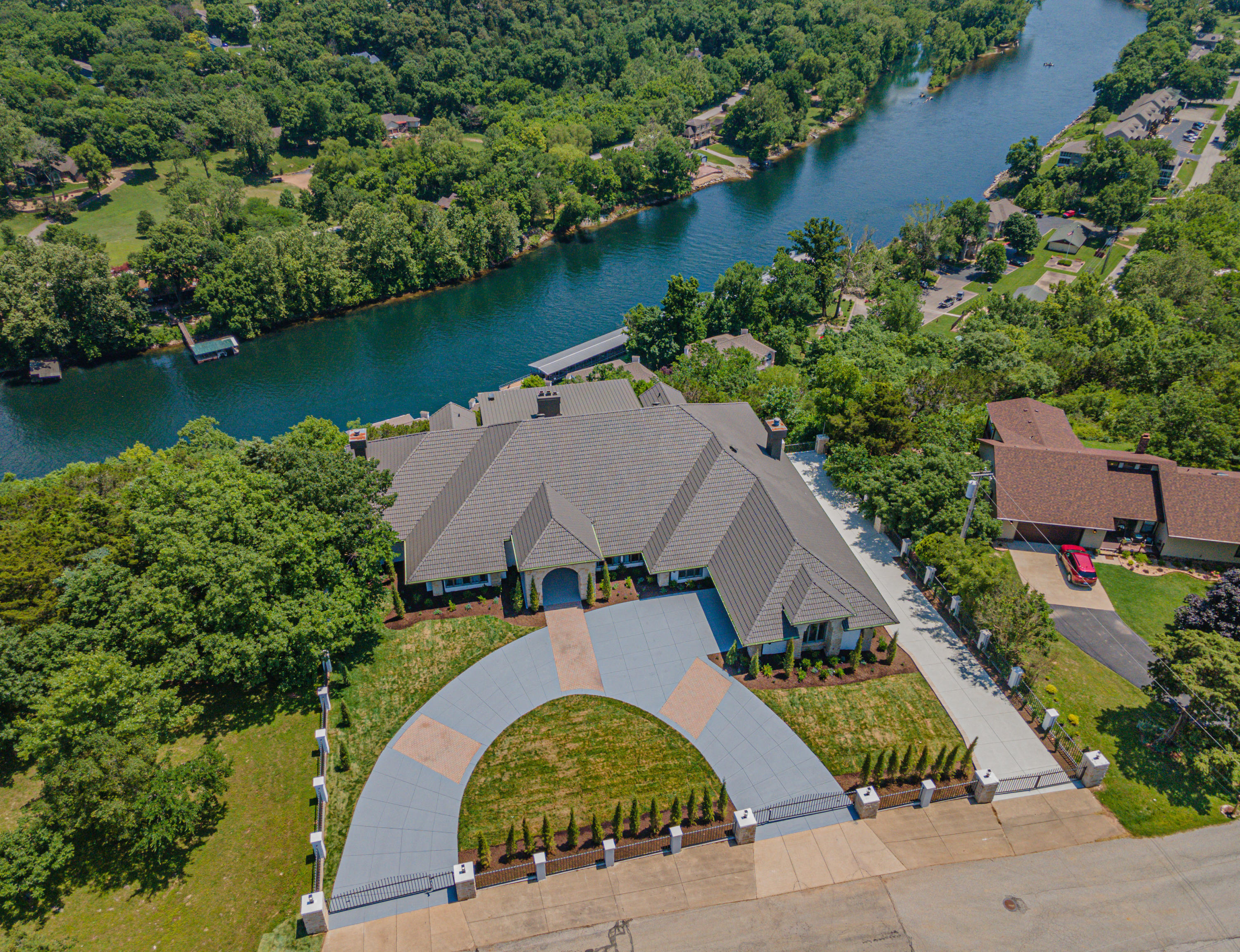 Rarely does an opportunity present itself to acquire the most enviable and exclusive property in Branson MO. Commonly known as the Cliff house, it sits on the highest point in Branson overlooking Lake Taneycomo and the Ozark mountains. This Cool, calm, and sophisticated, 8 Bedroom, 9 Bathroom, over 10,998 sqft estate, is enveloped in light and comfort with a layout designed for living and entertaining. This will be a feast to your eyes. From the moment you pull in the gate you will immediately notice the  Austin Stone Archway which is carried throughout the home.  Enter through the massive door with your name personalized above, revealing a majestic great room. Your eyes first will be impressed with soaring ceilings, the grand staircase and one of 5 fireplaces. Immediately from there they will be instantly drawn to the stunning panoramic Lake views which can be accessed from over 3,000 sqft of decking! Sit around your 15 foot live edge dining table that seats 14 or lounge in style in your sleek contemporary living room.  To your right you will find your dream come true chef's kitchen equipped to service 36 guests. Prepare your meals while visiting with family and friends in the open concept den with panoramic views from both areas.  Kitchen boasts custom cabinets, butler service area, pristine concrete counter tops, 2 farmhouse sinks, top of the line appliances including gas stove/range and electric convection oven. Off the kitchen you will find a prestigious study, or it could be an ensuite if you choose.  To the left you will find a spacious guest ensuite and then the show stopper primary Suite.  This suite is nothing short of amazing. Complete with a cozy fireplace and sitting area to drink your morning coffee watching bald eagles soar over the lake. Relax in your oversized soaking tub before you enter your massive robe room to get ready for the day.  Click ''more'' for further description.