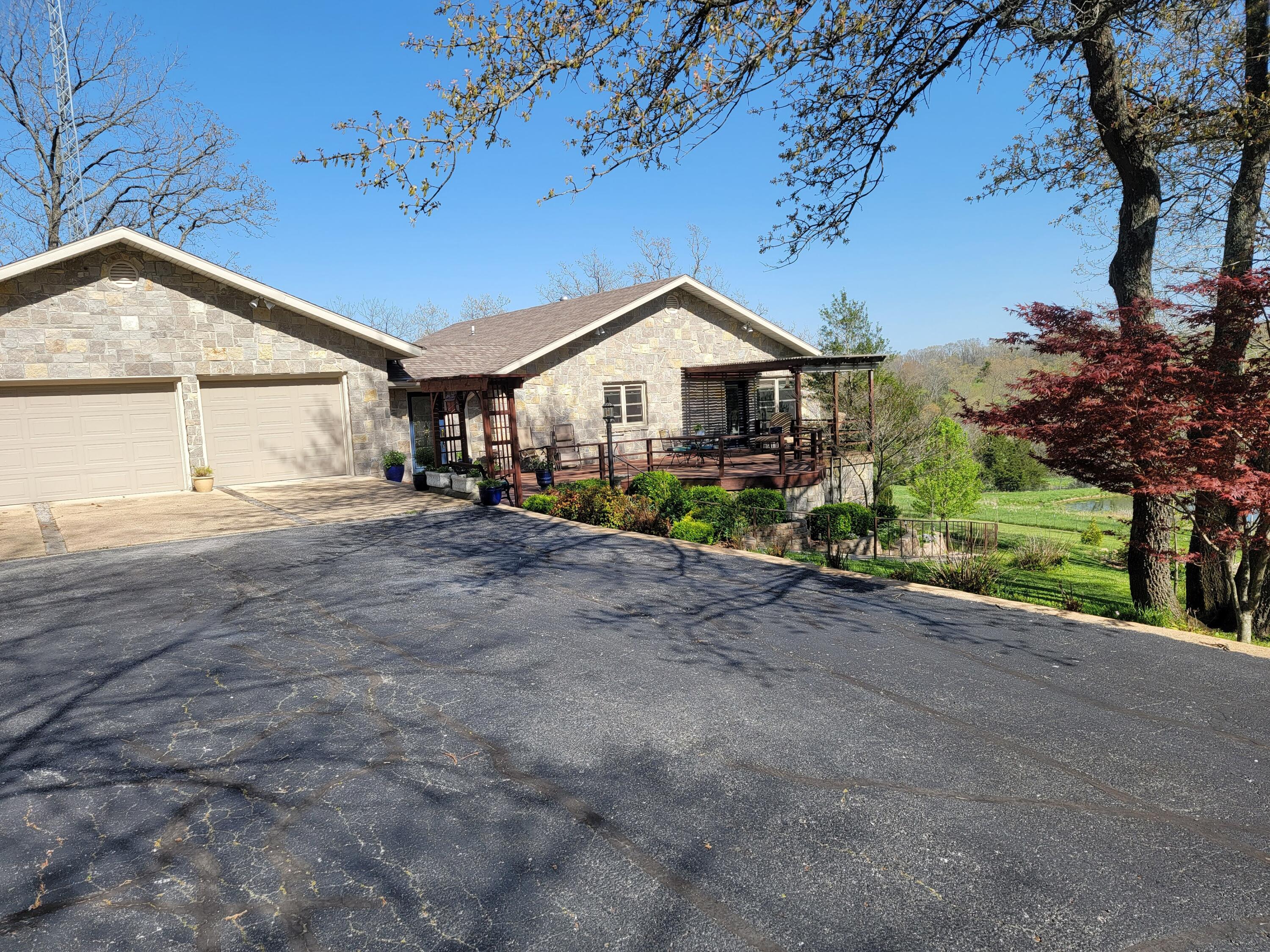 Luxury in the Ozarks! Look no further for a home that has everything!4 bedroom, 2.5 bathroom with a 3-car garage home with real stone exterior. Just over 3600 square feet including a full walk out basement on 13 plus manicured acres.Main floor master suite with built in dressers and its own fireplace. Master bath has heated floors with walk in shower, soaking tub, double vanities and large walk in closet. Also on the main floor is a half bath along with the dining room, formal living room with gas fireplace, a custom kitchen with Corian countertops, center island, 36'' gas range with hood and walk in pantry.  reverse osmosis in kitchen and hot water on demand throughout the house.Lower level includes a second living area, full bathroom, two bedrooms, a non-conforming bedroom/office space along with large mechanical room and walk in storage room.Property also has a very nice 24x30 shop with a hobby room inside, chicken house ready for your hens, fruit trees, raised bed garden boxes in a green house, beautiful front deck with pergolas and a paved driveway. Private road access with beautiful views with lots of peace and quiet.Located just over 50 minutes from Springfield, 9.5 miles south of Mansfield, about 1.5 miles off Hwy5. Give me a shout to view this magnificent home!  All it's missing is YOU!