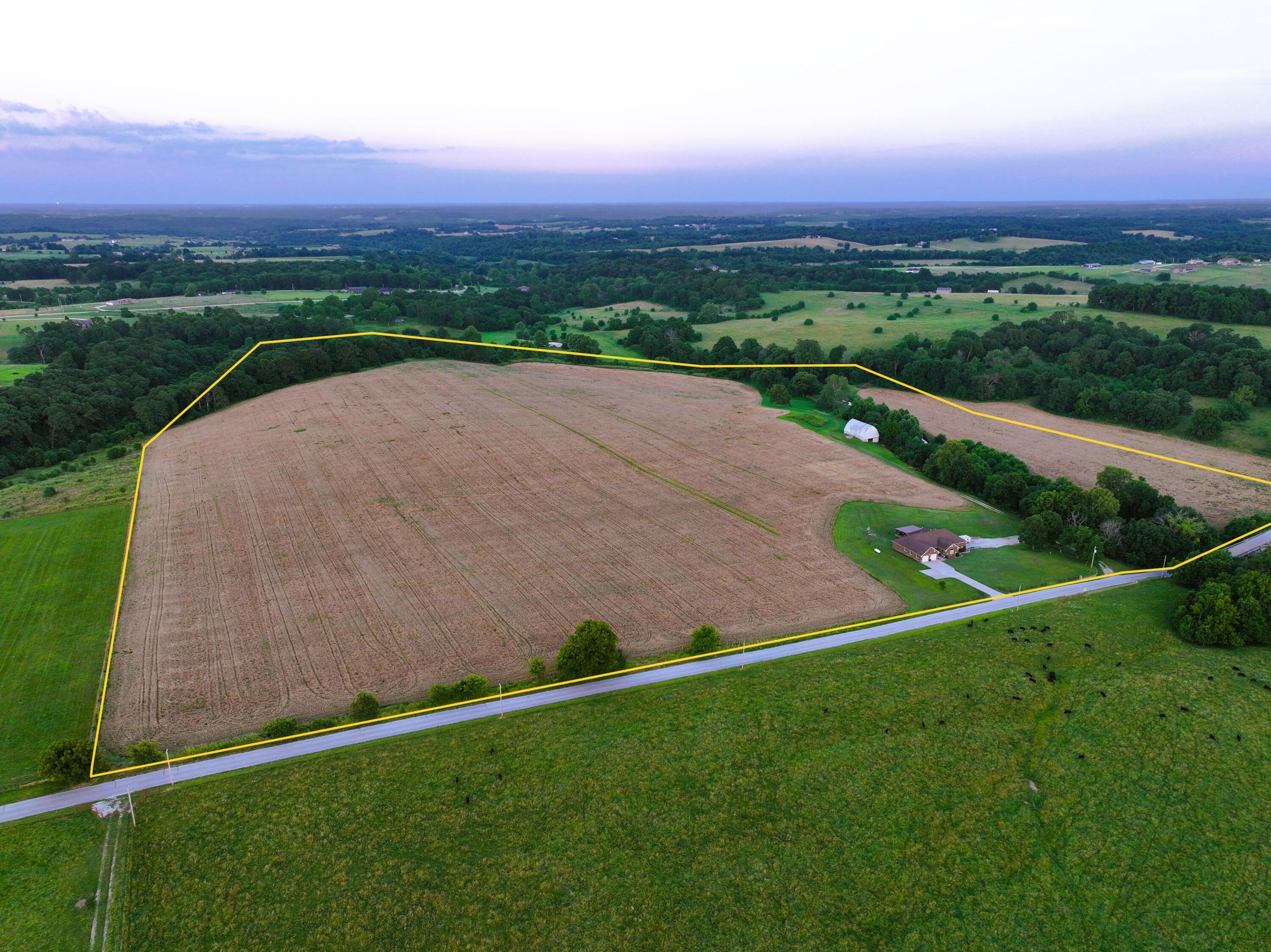 This custom-built, all-brick home on 70 acres along Terrell Creek offers a blend of spacious living and agricultural or development potential within the Republic school district. Approximately 90% of the property is tillable, with the remainder being timbered areas along Terrell creek, known to produce trophy-class deer. Built in 2016, the 5,300-square-foot home has 3,600 square feet of finished living space, including a main-floor layout ideal for entertaining with a large kitchen, dining area, sunroom, and living room, as well as large outdoor covered patio. Additional features include a two-car attached garage, a 1,000-square-foot, 3 car garage/workshop in the basement, and a flexible main floor with three bedrooms, two and a half baths, a large office, and a craft room that could serve as a fourth bedroom, playroom, or nursery. The large historic loft barn near the creek is in remarkable condition and has a ton of potential uses. The seller is open to selling the home with 5 to 10 acres, leaving the remaining 60-65 acres available with a multitude of great build sites.