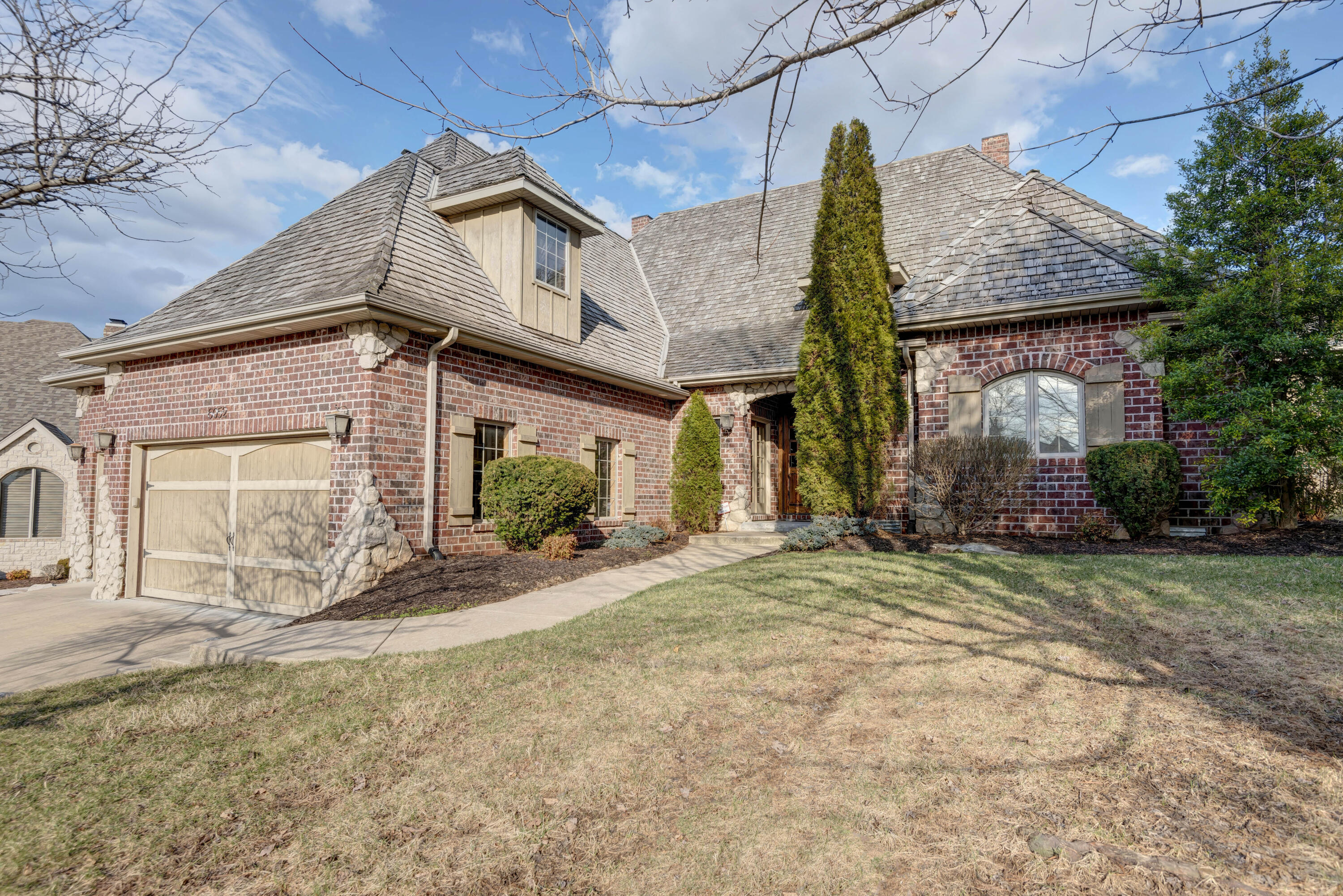 Magnificent home in the Millwood golf course community featuring 4 bedrooms, 2 1/2 baths, a 3-car garage and approximately 3,505 square feet of luxurious living space. This 1 1/2 story showplace features a grand entry with French doors, a formal dining room, living room with soaring ceilings, a gas fireplace, lots of windows flooding the home with natural light and beautiful hardwood floors. The spacious kitchen & hearth room with a second fireplace is truly the heart of the home with ample space for everyday family living & entertaining guests.  The cook in the family will love all the beautiful cabinets, center island, the beverage bar with wine fridge, the spacious walk-in pantry, granite counters and the stainless appliances with 6-burner gas range.  The main floor master suite offers a spectacular master bath with separate vanities, jetted tub, a large walk-in tile shower and two walk-in closets, plus access to a private patio.  Also, on the lower level there is a bedroom with French Doors that would make a wonderful office/study/exercise room or nursery.  The upper level boasts two large bedrooms with a Jack and Jill bath between.  The exterior of the home offers a charming, screened in porch, lush landscaping and a classic brick and stone French Country facade.  You will love the timeless architecture style of this beautiful home and the surrounding homes on this quite cul-de-sac street in this popular country club community.  Call today to schedule your private showing.