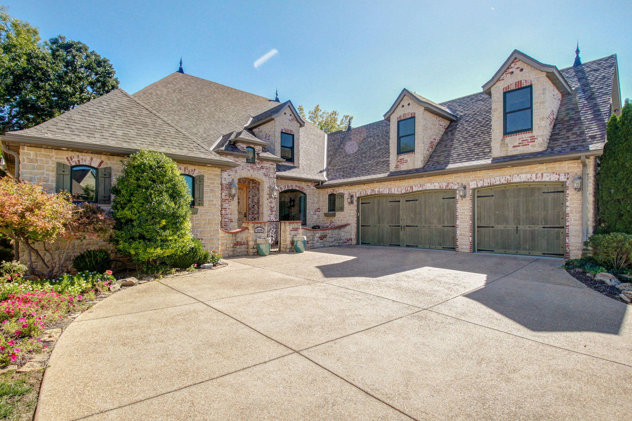 Welcome to St Andrews Club - the gated subdivision in Millwood where this breathtaking home sits on the 16th fairway.  This modern French country home is sure to impress with an inviting courtyard leading to the front door.  The nearly all brick home includes fresh landscaping, a new roof in 2023, two covered back patios and don't miss the path leading to the bonus room in the basement.  The interior offers newer modern paint, updated lighting, three large guest bedrooms, a great formal dining room, a dedicated office space with custom built-ins and multiple living areas with the main floor featuring cathedral ceilings, a gas fireplace and built in bookshelves.  The wooden beams highlight this chef's dream kitchen with ample space, newer quartz countertops, stainless appliances and freshly painted cabinets with a hidden walk in pantry.  Finally, the spacious, private master suite includes a large, tile, walk-in shower, a separate air jet tub, two vanities and a large walk in closet.