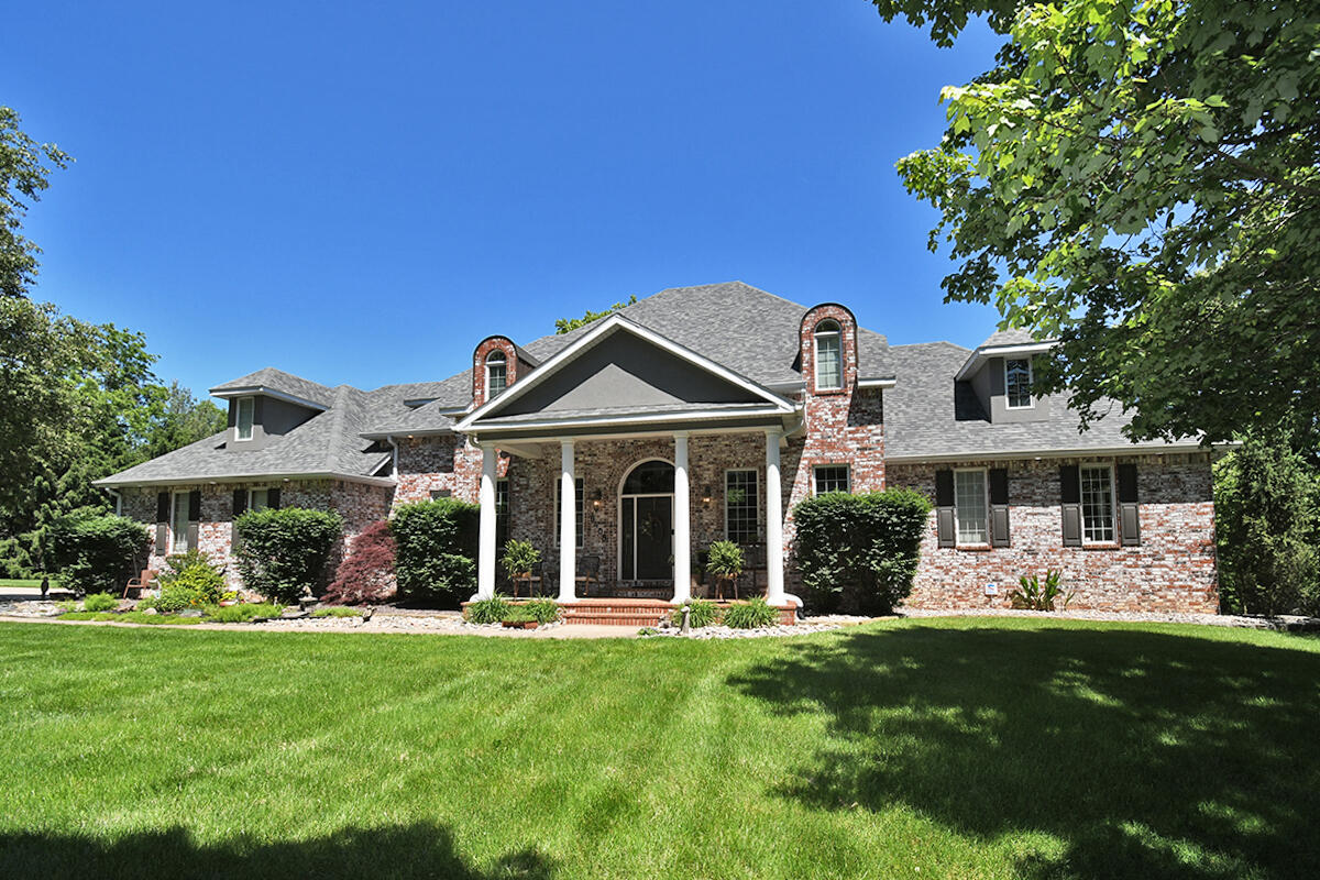 LUXURY CUSTOM-BUILT HOME ON 3 ACRES   This beautiful 3-story, all-brick home is the epitome of quality and charm. With 5854-sq.-ft. of living space, it provides several gathering areas as well as private spaces, complete with 3 lush, private acres that borders Highland Springs Country Club on 2 sides. The open concept design is set off with 2-story, soaring ceilings as soon as you enter. Everyone will congregate in the main living area and the spacious kitchen, which features an enormous wrap-around granite bar and an abundance of custom cabinets and counter space. The handy, walk-in pantry offers even more room to store away essentials and is large enough to tuck away a second refrigerator. Host even larger gatherings in the formal dining room. The thoughtful design is also evident in the layout of the 5 bedrooms. The huge primary bedroom is located on the main level. Upstairs, you will find 2 large bedrooms connected by a bathroom. A third room could be an ideal playroom, nursery or office. You will also find a partial, floored attic space on the upper level. This home does not lack for storage with huge closets in every room and built-in storage everywhere. Two more bedrooms are in the incredible, walkout basement, which also features a large living area, a full wet bar and 2 full baths. Another basement room makes for a wonderful fitness room or could easily serve as a theater room, playroom or office. The home offers many ways to enjoy the amazing grounds, including a screened porch, a deck, a patio and a beautiful firepit surrounded by flagstaff stone. From its practical floor plan and quality extras to its acreage and location near the Ozark Greenway Trail, this home has it all - with character to spare! Make time to see it today.