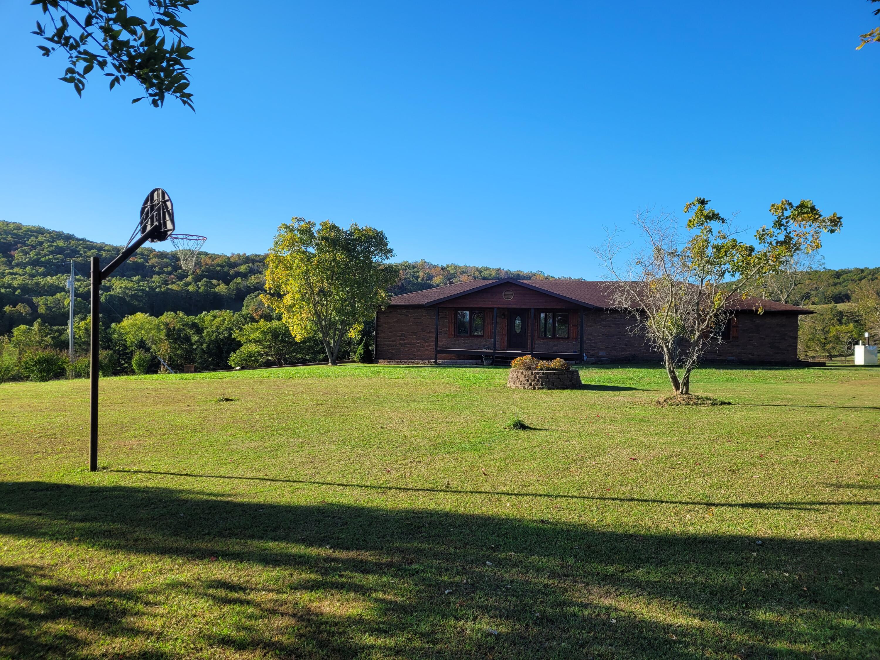 This is one of those properties that almost never come available. 400 acre cattle or hay ranch with privacy and seclusion but only 30 minutes from Ava Mo and 30 minutes from Branson Mo. With over 320 acres in improved pasture with 90 percent of that being hay producing. Seller ran 85 mama cows and on a normal year never fed hay until first of Feb. Property has a very nice brick home that sets at the end of about a quarter mile of private drive of of a paved county road . The 60x40 insulated all steel shop sets close to the home and there are 4 more barns on the property with close to 500 round bale storage. This ranch is bordered on 2 sides by Mark Twain national forest the views from this property are amazing as well as the hunting. The property has excellent perimeter fencing and is cross fenced and is set up for rotational grazing with 12 current grazing areas with water in each.  There is a working cattle facility with pens. And there are 11 ponds on the property with almost all areas having access for livestock to water . There are 2 wells on the property  with the second well providing opportunity for a second home with plenty of distance away from current home. This really is a exceptional property with pride of ownership shown in every part of this ranch.