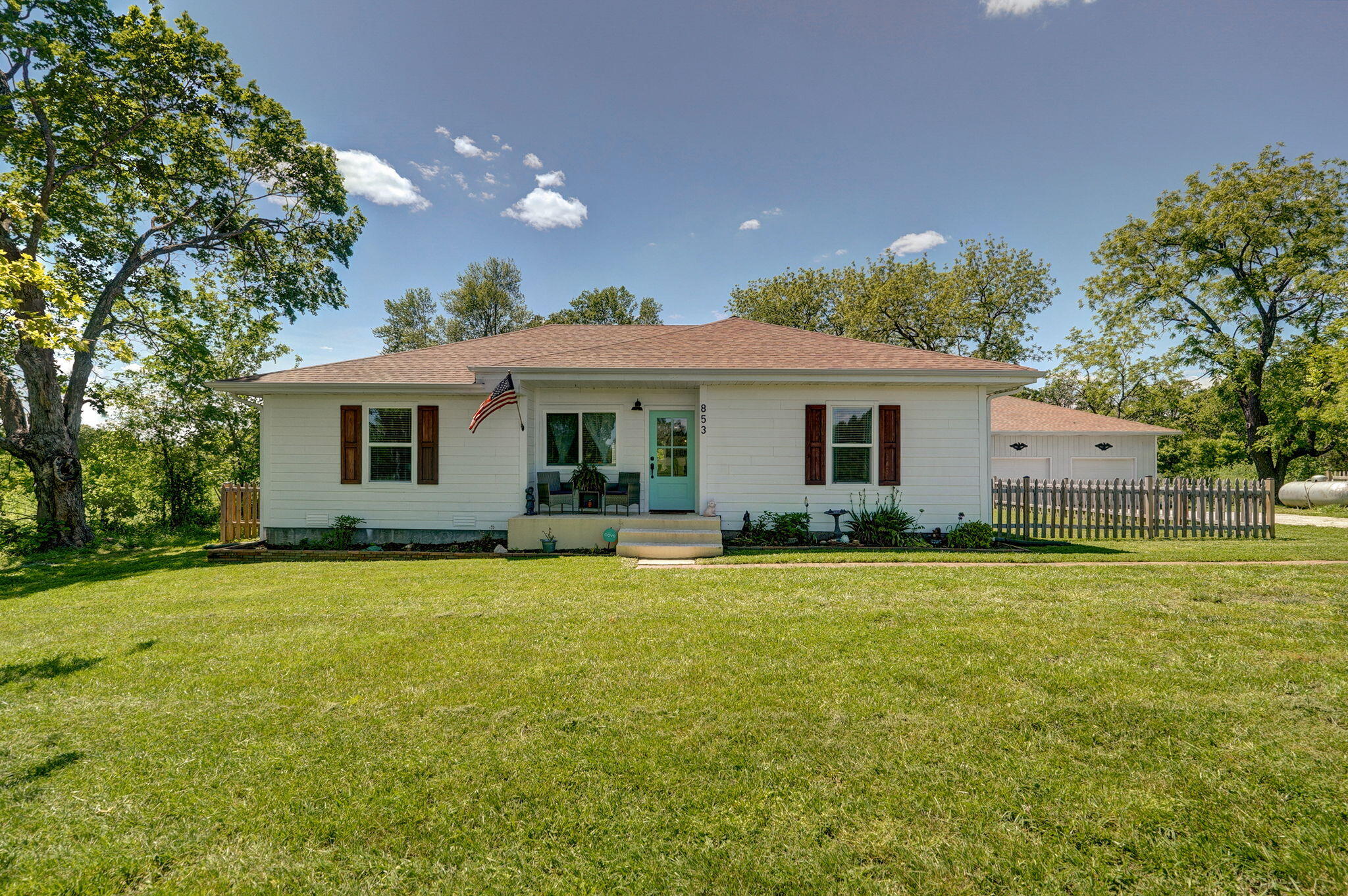 Built in the early 1900s and renovated from top to bottom, this charming farmhouse is located on acreage, with a pond, and has everything you could ever want. Situated on 5 acres, this mini-farm offers open concept living with 4 bedrooms, 2 baths , a 30x50 oversized 3+-car garage/shop and a large barn (+milking barn and lean-to) and chicken coop plus 2 separate fenced areas. The home was completely redone by the previous owner. The open living, kitchen and dining is so inviting and great for you and your guests. The kitchen was redone with white cabinets, quartz countertop and all appliances stay! The large master bedroom features raised ceiling, french doors for master closet/laundry and the Samsung washer and dryer also stay! Master bath has soaking tub and rainfall shower.  3 additional bedrooms and very nice hall bath with walk-in shower finish out the home. SO MANY UDPATES you can see and ones you can't see: PEX plumbing and electric wiring (2021); foundation work to level living room floor; additional work in crawlspace in 2023; new roof on house and garage (late 2021); new front garage doors with wifi (2023); new septic tank (2021); whole home water softner(2024); new front door & windows on front of house; Luxury laminate wood flooring (pet and scratch-resistant) throughout the entire house; light paint colors; new millwork & solid doors throughout the house; new Hardy plank exterior (2022) and paint. In the backyard you will find a new extended back patio and full picket fence with double gate in the back.In the barn, electrical has been rewired for new lighting and outlets throughout; a new custom barn door was added; a charming new custom chicken coop with solar lighting was built & a no-freeze faucet was added. Enjoy use of the milking barn, extra large hayloft and 5 stalls.This is a must -see home on acreage!!