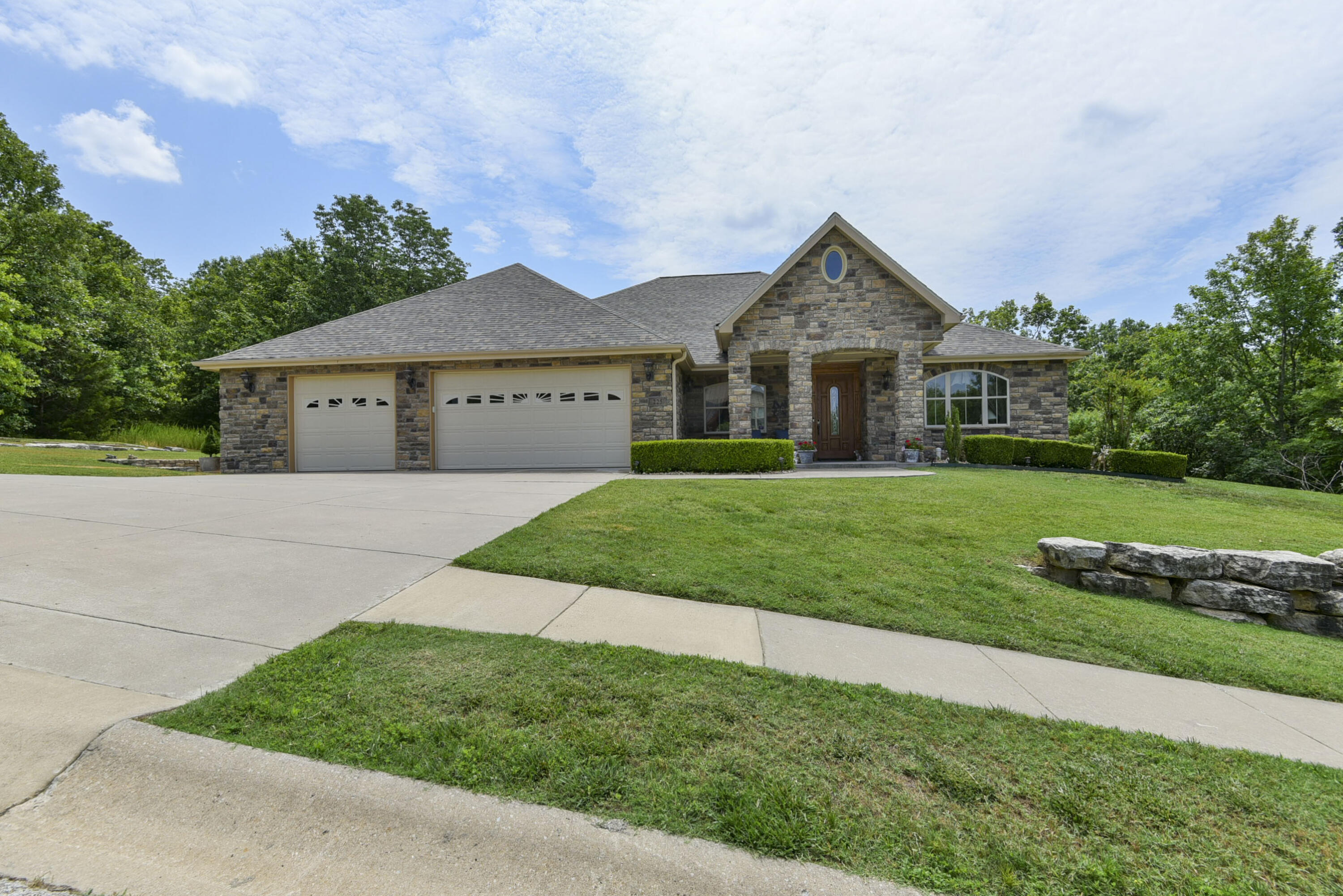** OPEN HOUSE 7/1/23 10a-12p ** Exceptional quality abounds in this custom-built well cared for home located in prestigious Oak Knoll at Branson Creek. This one owner home all on one level features a split open floor plan, 10-foot ceilings, living room fireplace flanked by built-ins, huge office, and fully-finished enclosed sun room. The kitchen provides granite countertops, double sink with 3rd basin, appliances less than a year old, ample cabinet space with bottom cabinet rollouts, and corner pantry. Just off the kitchen is an additional larger pantry for more storage. New composite wood flooring, beautiful trim and finishes including 2,000 linear feet of premium crown molding. All of the doors, cabinetry, and trim is solid oak. The superb construction includes concrete grade beams in the poured concrete foundation. The private master suite has walk-in closet and master bath equipped with double vanity, walk-in shower, and walk-in tub. Oversized 3-car garage, air conditioned, storage cabinets, and more storage in the attic with pull-down stairs access. Water softener and water filtration system located inside the garage. There is also a 1-car detached garage/workshop that has A/C and matches the house. Outside the garage is a $40,000 Diesel Generator, so no need to worry about being without power. Stone front exterior and durable fiber cement siding that has been freshly painted. Brand new roof June 2023. Wonderful curb appeal and beautifully landscaped with large stone retaining walls and well-manicured front and back yards. Fully fenced (wrought iron) in back yard. This immaculate home is located within a few short minutes of championship golf courses, and close to everything Branson has to offer, shopping, dining, shows. Schedule your showing and come see this fabulous home today!