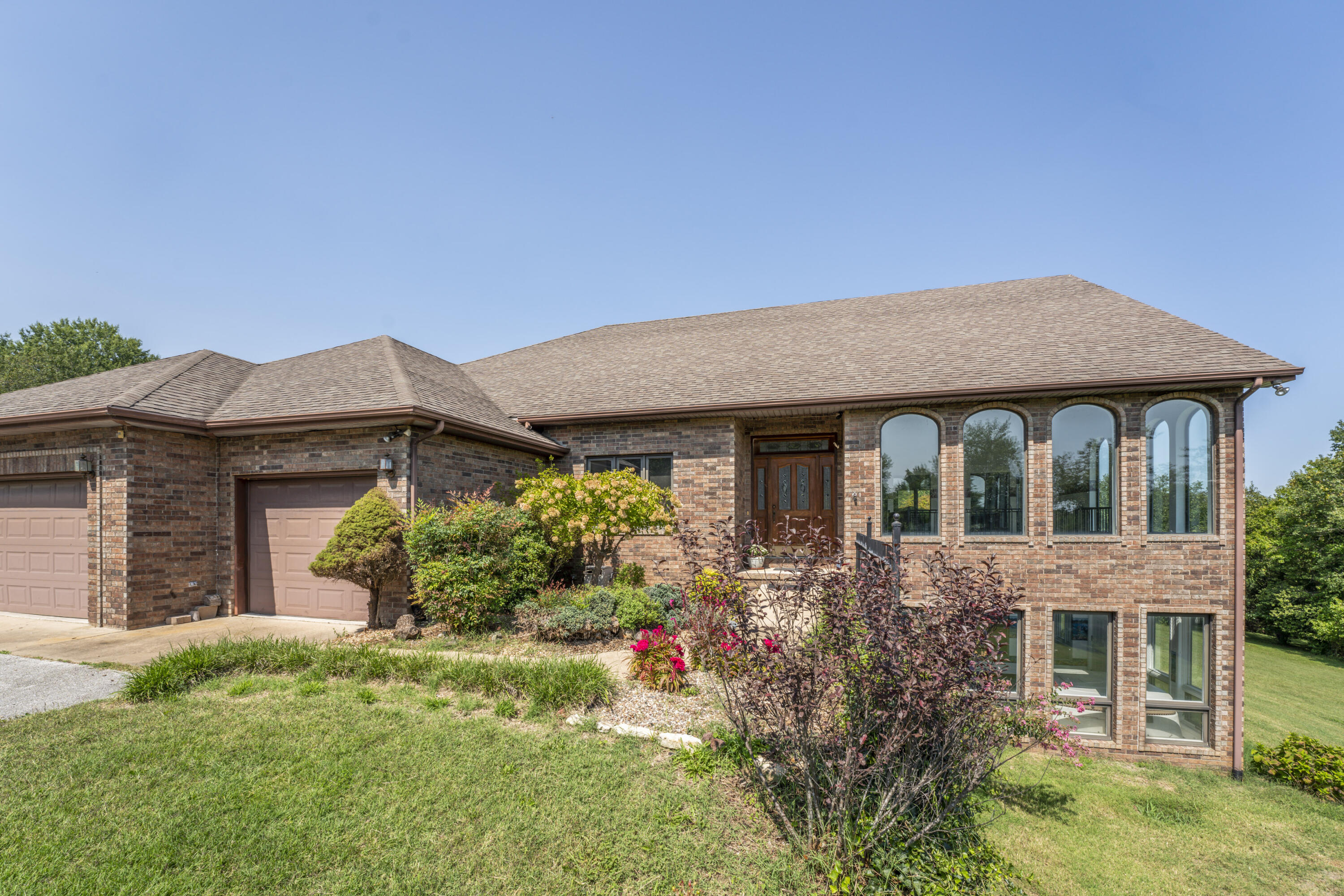 If you're looking for country living with all the benefits of being close to town - check out this one of a kind custom built home with a walk-out basement in Nixa!  Over 3 acres of mature trees grace the landscape along with cherry, apple, peach and fig trees!  With over 5,000 square feet this home was made to entertain! As you enter, a large sunroom/atrium is off to the right with stunning arched windows lining the room and flooding the home with natural light. A large chef's kitchen with a dining area, breakfast nook, island, and bar, leave plenty of space for gathering the family for holidays or parties. The great room has soaring ceilings, brick fireplace, and large windows looking out over rolling green hills.  The wood deck off the dining room is the perfect place to watch deer graze while you enjoy your morning coffee. The master bedroom boasts dual walk-in closets, jetted bath tub, and walk-in shower. Another 1/2 bath and laundry room off of the garage complete the main level. Downstairs is where the fun begins!  An enormous Rec room leaves space for all kinds of fun! A wet bar with plenty of cabinets makes this area ideal for movie or game nights! Three more bedrooms (2 non conforming - closets, no window) can also be used as an office, or work out area. There are multiple storage areas, bathroom and a large sunroom on the lower level as well. The owner has installed a new hot water heater, air conditioner, and furnace this year. The roof is around 5 years old. Air Service Heating & Cooling/All Service Professional Plumbing membership has been paid for through the end of the year and can be transferred to new owners. Come check out this amazing home with serene views from just about every room!