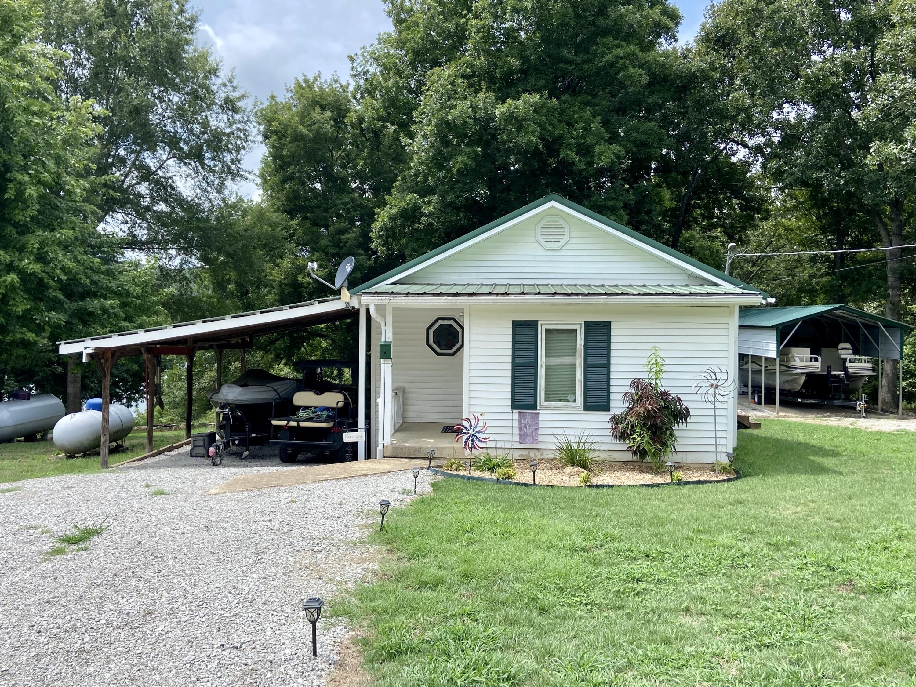 Just bring your fishing pole, its ready for fun filled lake days! This cabin is located on the Big Creek arm of Bull Shoals Lake at Nolan's Point. This 2 bedroom, 1 bath was recently remodeled. A total kitchen make over, new flooring, shiplap walls, and white sliding barn doors are just a few of the updates that make this quant home have a modern feel. The home features a large covered back porch with a great lakefront view that adjoins take line of the lake. An easy walk to the water, you can swim or fish right off the gravel bank. A boat launch is less than 1/4 of a mile from the property. Another recently added bonus, the property has a detached carport, 35'x12' , currently storing a pontoon boat. *Pontoon is for sale by owner, not included with property listing.*House is being sold in 'as is' condition