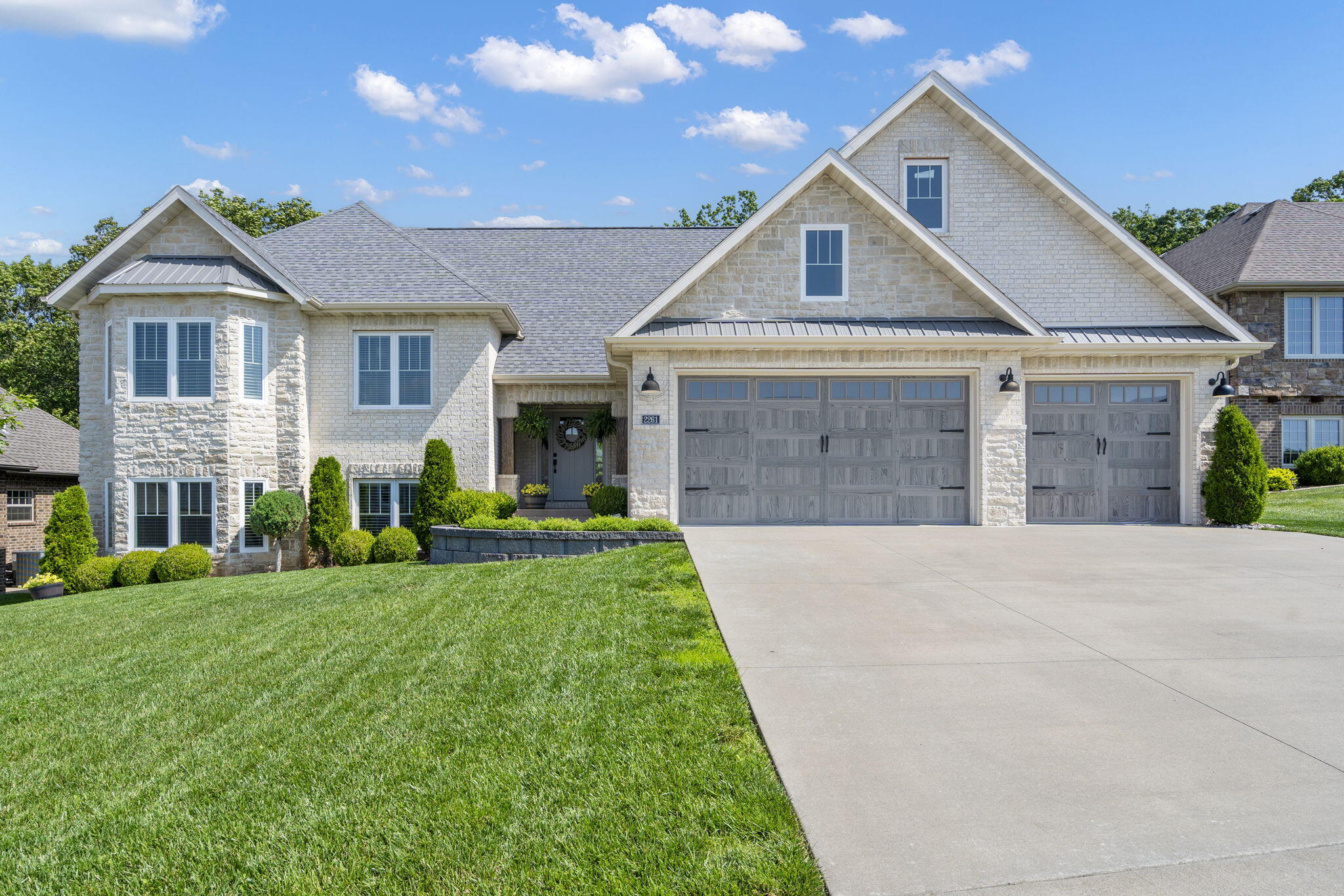Welcome to this meticulously maintained, custom-built, one-owner home, constructed in 2018. Located in the desirable subdivision of Wild Horse, this exquisite brick and stone split-level residence offers 5 bedrooms, 3.5 bathrooms, multiple living areas and a 3 car garage. Upon entering, you'll be captivated by the high ceilings and the elegant hardwood floors with beautiful tile inlays. The open-concept design seamlessly connects the living spaces, creating an inviting atmosphere. A striking stone dual-sided fireplace serves as a central feature, providing warmth and ambiance while elegantly dividing the living room and the gourmet kitchen. The living room offers ample space for gatherings, with large windows allowing natural light to flood the space. The kitchen is a chef's dream, boasting an oversized island. Features include dual wall ovens, a cooktop, and a spacious pantry. The quartz countertops and custom lighted cabinets, complete with deep drawers and custom pullouts, add both style and functionality. The primary suite is a true retreat with high ceilings and plenty of natural light. The ensuite bathroom is luxurious, featuring an entire wall with a double walk-in fully tiled shower, a soaker tub, dual vanities, a toilet closet, & a large walk-in closet with built-in cabinetry, providing ample storage and organization. The walkout basement  features two additional bedrooms, a full bathroom, and a large entertaining space.It opens directly to the backyard, creating a seamless indoor-outdoor living experience. The private backyard is bordered by a treeline that offers both beauty and privacy. The covered back patio is perfect for outdoor dining or relaxing. A 2nd patio area is prepped with a hookup for a future hot tub. This stunning split-level home combines luxury, comfort, and modern amenities, making it an ideal choice for discerning buyers seeking a high-quality, well-maintained residence. This home is sure to impress!