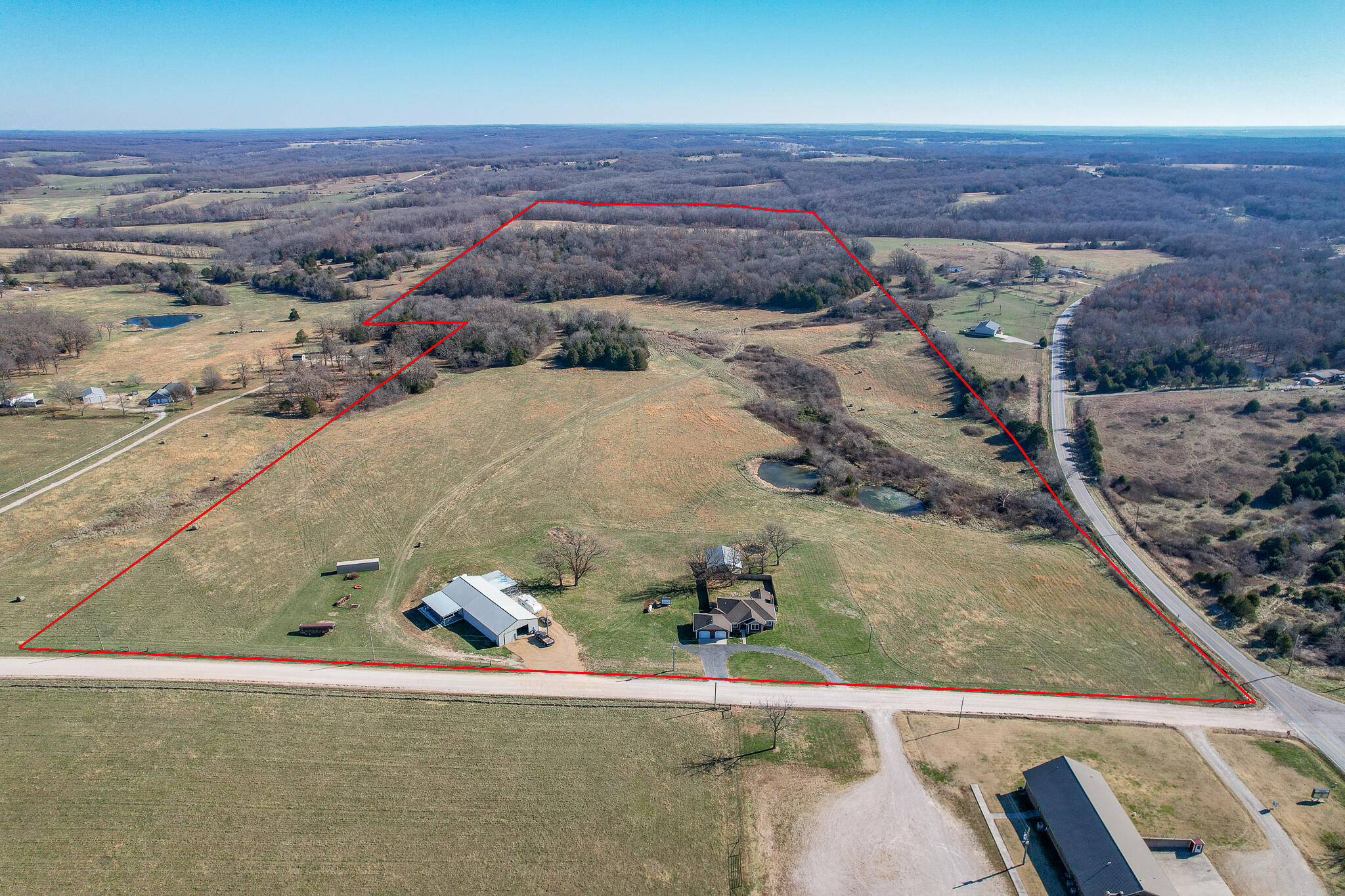 Your home on the range is calling! This 101 beautiful acres and is set up and ready for your livestock, horses, or hobby farm. The residence has been completely updated from top to bottom. Improvements include new seamless metal exterior siding, new flooring in living room & kitchen, granite countertops, fresh paint, and stainless kitchen appliances. The kitchen offers high quality appliances & more cabinet space than you could ever need. Take in the priceless views from the screened in back porch. The sprawling outdoor area also includes a privacy fenced back yard,  a one-of-a-kind pavilion for outdoor gatherings, and a large pond. Roof is 4 years old with 50 year shingles that will withstand 350 mph winds. Keep your heating bills low with the large outdoor wood furnace. Store all your farm equipment and toys in the massive 40x100 shop building with electric, concrete floor, and attached exterior kennels. Several acres are currently used for hay. A perfect blend of wooded and cleared land, with a wet weather creek that winds through the gently rolling pastures. Life doesn't get much better than this, call for a private showing today!