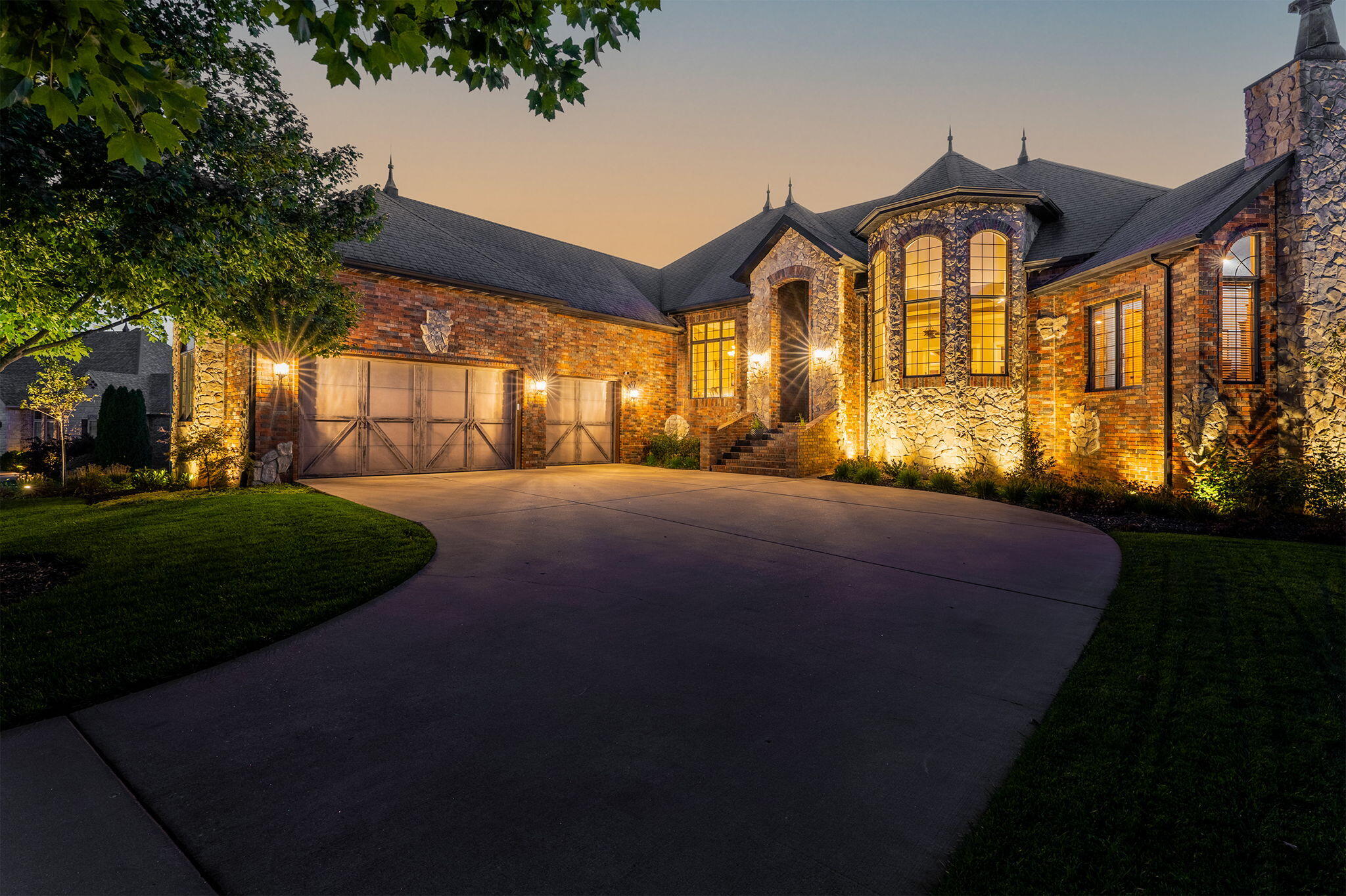 Immaculate all brick and stone home in the gated Windsmore subdivision! This property offers 4 beds, 4 full bathrooms, powder room, 3 living areas, 2 offices, a theater room, recreation room, walk-in closets in all bedrooms, and more! The main level offers a formal living area and dining room with tall ceilings, crown molding, and 3/4' solid hickory hardwood floors. Kitchen features granite counters, cherry cabinets, a bar w/seating, stainless appliances, and an attached dining area with wine storage and beverage fridge. Off the kitchen is access to a covered deck and a hearth room with gas stone fireplace. The primary suite boasts a gas fireplace, tray ceilings, direct access to the deck, and a beautiful bathroom with vaulted ceilings, jetted tub, walk-in tiled shower, two vanities, and 2 walk-in closets! Completing the main floor is a 2nd bedroom w/private bathroom, office w/fireplace, powder room and laundry room! Down a beautiful staircase is the walk-out basement with expansive living area, the 4th fireplace, wet bar, exercise room, large theater room, office, 2 more bedrooms with their private bathrooms, and John Deere room with exterior doors. Basement walks out to backyard with covered patio and spacious yard w/ access to walking/bike trail. Home has been modernized with exterior and landscape lighting, LED interior lighting w/ dimmers, whole-home audio, energy-efficient reflective window treatments, recirculating hot water system, and app-controllable thermostats. Schedule your private showing today!