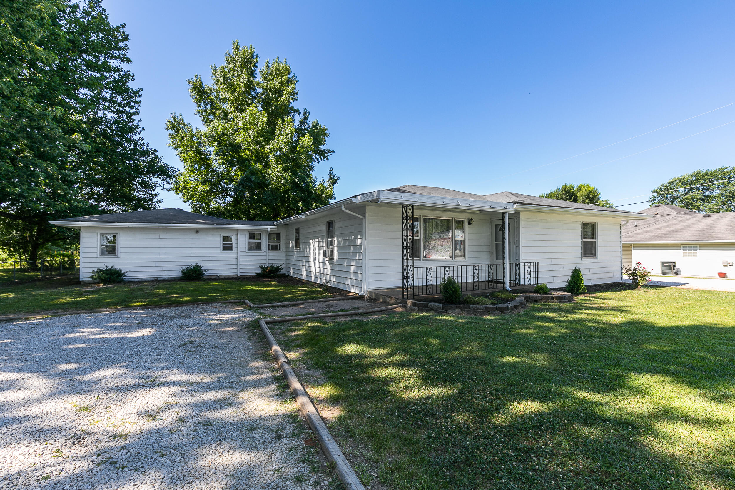 Would you like a little slice of land while being in the middle of it all???  This is it!  This roomy and well-cared-for home is on almost 2 acres and is just a stone's throw from Willard High School!  This huge, level, lot gives you enough space  for a soccer field and a big garden and is just minutes from dining, shopping.  The location offers very quick access to 160 for the short drive to Springfield.  The home has easy to care for flooring throughout with some flooring being original hardwoods.    You will love the large living room, big kitchen and a big mud/laundry room!  The detached two car garage is oversized with plenty of space for storage and/or a work bench.  Don't miss the partially finished room on the back side of the garage with power and climate control that would make a great home office, hobby space or additional storage.  The big covered back porch is the perfect place to sit and enjoy the view of your own park-like yard with a small fruit orchard. With two driveways, you will have plenty of space for parking.  This home has so much to offer!  Seller will leave the window units for cooling, they do a great job!