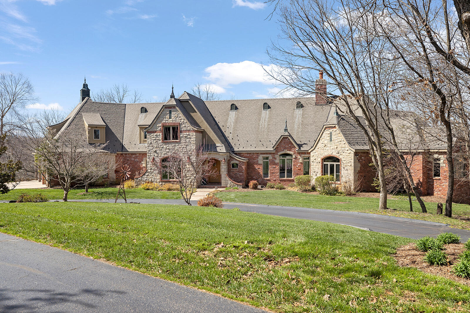 This gorgeous, secluded estate welcomes you home with extraordinary views, exceptional hunting and elegant living! Located only 20 minutes outside of Springfield & tucked back on a private drive, this French-Country custom home was tediously built with no small detail overlooked. Positioned to overlook Goose Creek running through the property, this home features gated entry, intricate hand-hewn stone & brick masonry, and is prepared for livestock. Walking into the estate, you are greeted by an elegant staircase, large windows providing an abundance of natural lighting, natural beams, cathedral ceilings, and an eye-catching floor-to-ceiling stone fireplace. The expansive kitchen features custom cabinetry, Sub-Zero, Thermador & Bosch commercial-grade appliances, a gas range, kitchen island seating, granite countertops, and a butler's pantry. The oversized study/home office space displays old-world style bookcases. The master ensuite features a private deck overlooking the creek. There is a convenient wet bar & half bath, perfect for your guests while entertaining on the gorgeous patios & swimming pool. Accessible from the garage, is a staircase leading to the unfinished basement, equipped with plumbing and a HVAC unit ready to be finished out. Upstairs, you will find two guest suites with bathrooms, extra storage closets, and a bonus room that could be used as living space or another bedroom. Fiber optic internet runs the house, shop and gate security and smart home automation technology including a security system with cameras, lighting and speakers throughout the interior & exterior of the home. This property also features a 48x72 shop building with 110 and 220 electricity, 3 horse paddocks with shed rows and automatic waterers, 3 fenced paddocks with slick wire for horses and a bottom grazing pasture for horses or cattle, a raised 20x30 irrigated garden bed,and 3 food plots for deer & turkey. This property is not to be missed, it is truly extraordinary!