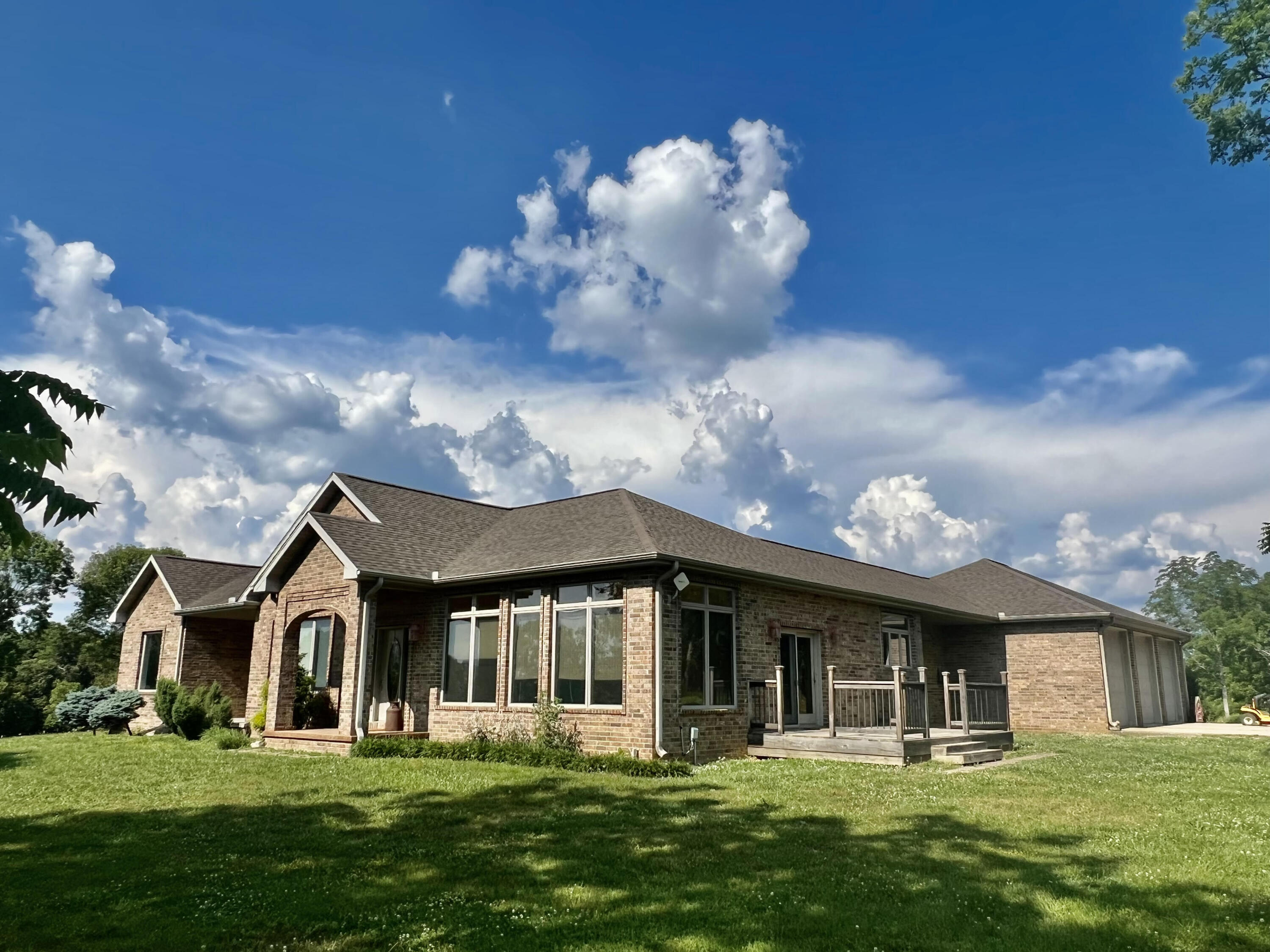 Serenity is the description for this all brick beauty on 15 acres, m/l in the West Plains School System. Timeless and Traditional with an amazing flow to the spacious living areas! You will love the soaring beamed ceiling of the great room complete with pretty property views, fireplace and unique built-ins for storage. Dream kitchen with tons of custom maple hardwood cabinets, topped with neutral black granite affords space for multiple cooks, making great family time. Large sunroom on front of the home with walls of windows that overlook the beautiful acreage. Huge mud room from side entrance has great custom storage, first floor laundry area and full bath with tiled shower. The huge primary en-suite includes private office with built-ins, barn doors, bedroom with beamed ceiling, sitting area and multiple windows for those peaceful outside views; bath has walk-in tiled shower, free standing soaking tub and room-sized walk-in closet. Full finished walk out basement has 3 to 4 bedrooms, 2 full baths. Awesome double-sided fireplace is inside the family room and inside one of the large downstairs bedrooms. Nice 2nd kitchen area with pine wood cabinets and 2nd washer/dryer connections make this a perfect separate living quarters if needed. Lots of extras like water softener, vacuum system and large safe room/storm shelter. Property is so very private, home is surrounded by beautiful pasture and overlooks two nice ponds. Breathtaking views and sunsets! It is a MUST SEE!