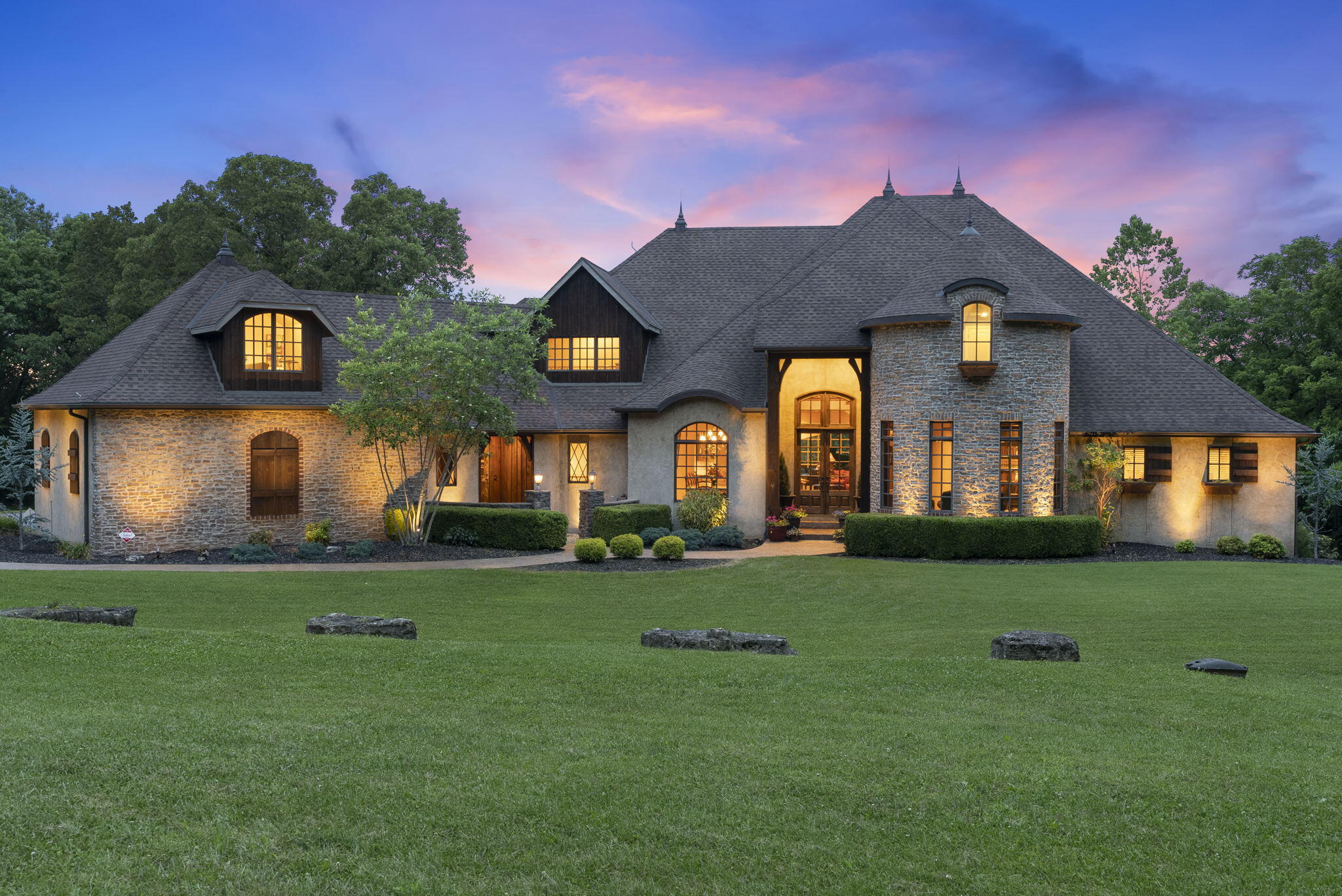 630 Woodwind Drive in Nixa, Missouri is the luxury estate you have been longing for. Prepare to be impressed as you enter the drive and pass the water feature on the calming drive to this magnificent home. This Country French estate  boasts over 9100 sq. feet and sits on 17 picturesque acres that includes a spring fed creek that runs all year and is located on the back of the property.This gorgeous estate was built by luxury home builder Arlan Campbell and was constructed of the finest quality materials. This home features 3 large living areas, 4 bedrooms and an additional bedroom and bathroom in the basement.  The basement also includes a huge wet bar area and is complete with 4 built in St. Louis Cardinals seats from the original Busch Stadium, a media room that includes the surround sound and wiring.  Adding to the charm of this home is multiple floor to ceiling stone and brick gas fireplaces,  a formal dining room with a walk thru butler's pantry. The amazing, open kitchen/dining/hearth room has a chefs grade stainless steel appliances, double dishwashers, double ovens, and large walk in pantry with floor to ceiling surround shelving with beverage fridge. Multiple spaces to entertain inside and outside of this home including a screened in porch off the hearth room. The upper exterior covered deck has soaring ceiling, chandeliers and multiple views of this gorgeous property.. A spiral staircase leads you to the lower covered back patio featuring a gas fire pit and hot tub for your enjoyment. This little slice of heaven also features a 30x50 (1500 sq. ft.) barn on the property and a  already graded backyard that is a perfect location to build a cascading in-ground pool on the property.