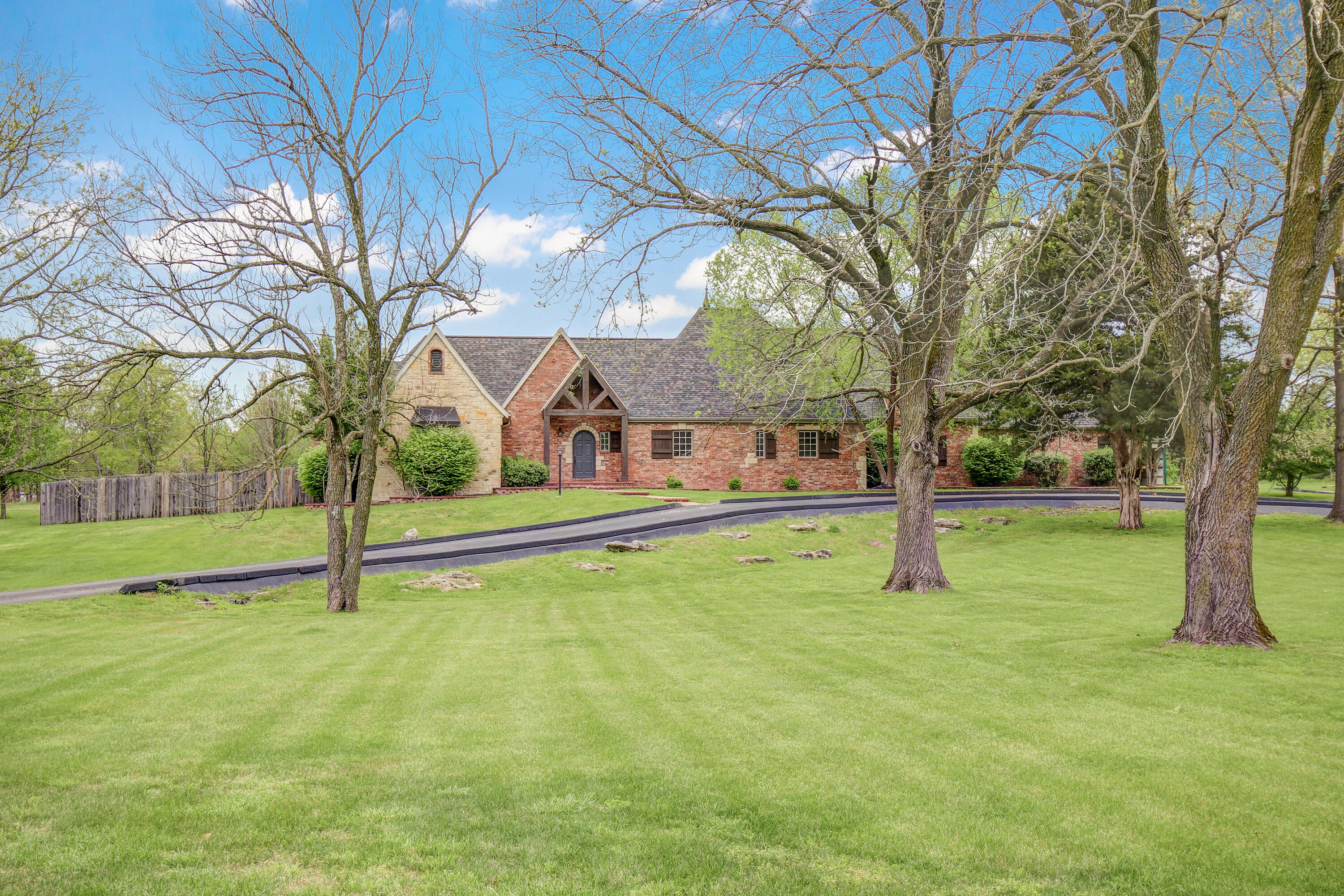 Stunning home in Rogersville Schools on 5.06 park like acres. This home offers beautiful high-end finishes, with rough hewn beams, lots of natural light, built in shelving, White Oak wood floors throughout the living areas and updated carpet from Mouery's Flooring, 3 bathrooms fully updated in addition to a large laundry that has been updated, a new roof in 2019, 4 bedrooms, an office, a workout room, 3 living areas, a screened in porch, covered patio that is plumbed for an outdoor kitchen and SO MUCH MORE! Make sure to check out the floor plan layout of the home included in the pictures section. The Master bedroom has a private entrance to the back deck, a large en-suite bathroom with his and her vanities, soaking tub, walk-in tiled shower with two shower heads and two huge walk-in closets with built-in shelving. The main level includes two additional bedrooms, an office, 2 bathrooms, a large laundry room, mud room, workout room, a beautiful screened in porch, covered patio (plumbed for gas) in addition they have two locations with 220 for hot tub (under pergola and on master bedroom deck). The basement has the 3rd living area or 'Man Cave' with movie screen, projector and surround sound, a 4th bedroom and access to the crawl space. Over the garage is an exceptional amount of attic space with a full staircase to get access.  The long driveway with a huge circle loop, 3 car garage and loafing shed located out back. Call to schedule your private showing today!