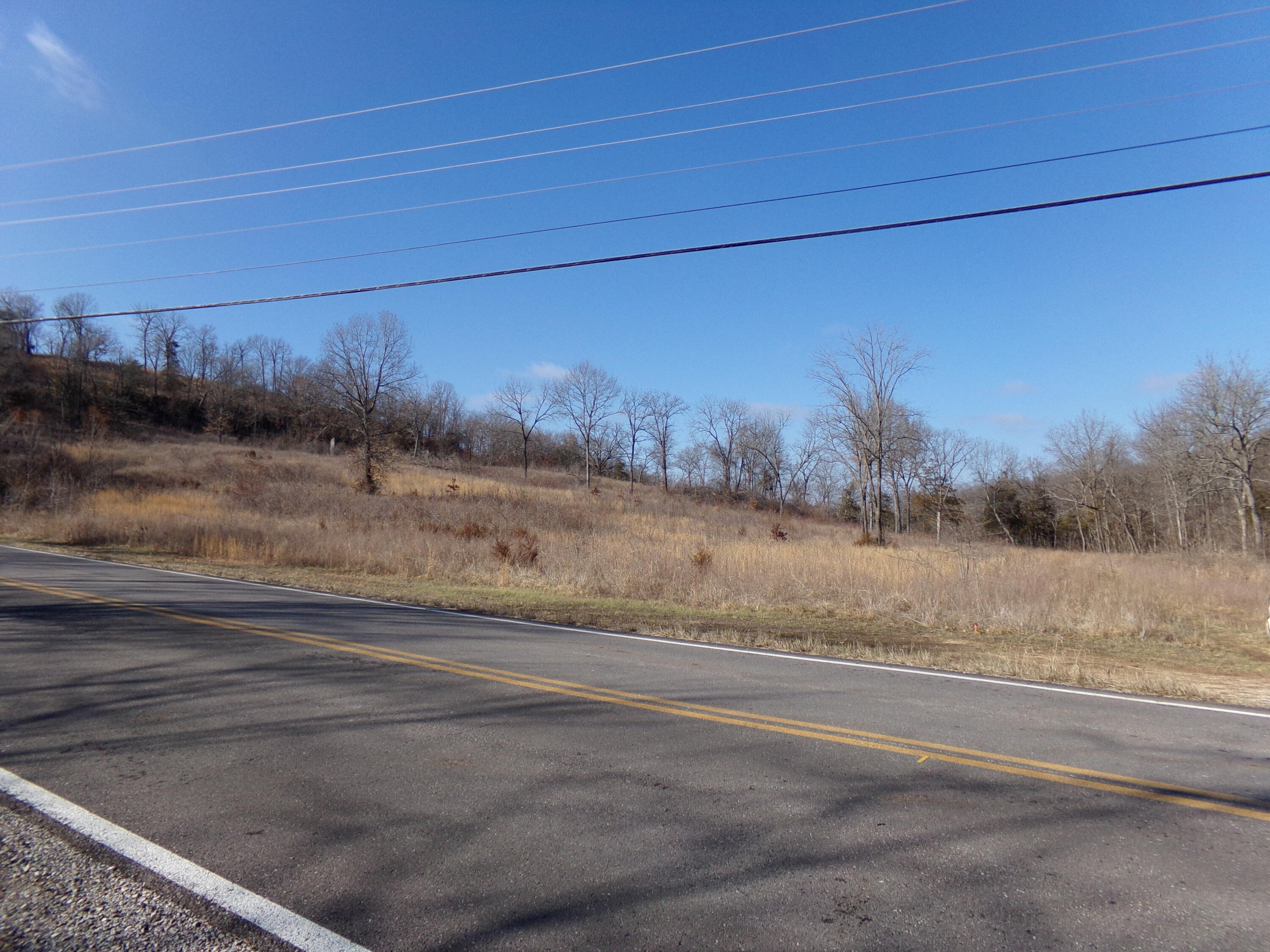#2784: 48 acres M/L on hwy. 90 just west of business 71 jct. Spring branch at east side of property, and paved highway frontage. Great location, just north of the Arkansas line! But in McDonald County Missouri, where the taxes are low, and no restrictions. Great place where you could have a business and live on the property. Or build whatever you want to., without costly permits. Although it is showing in the city of Jane , so you may have to double check with the city.