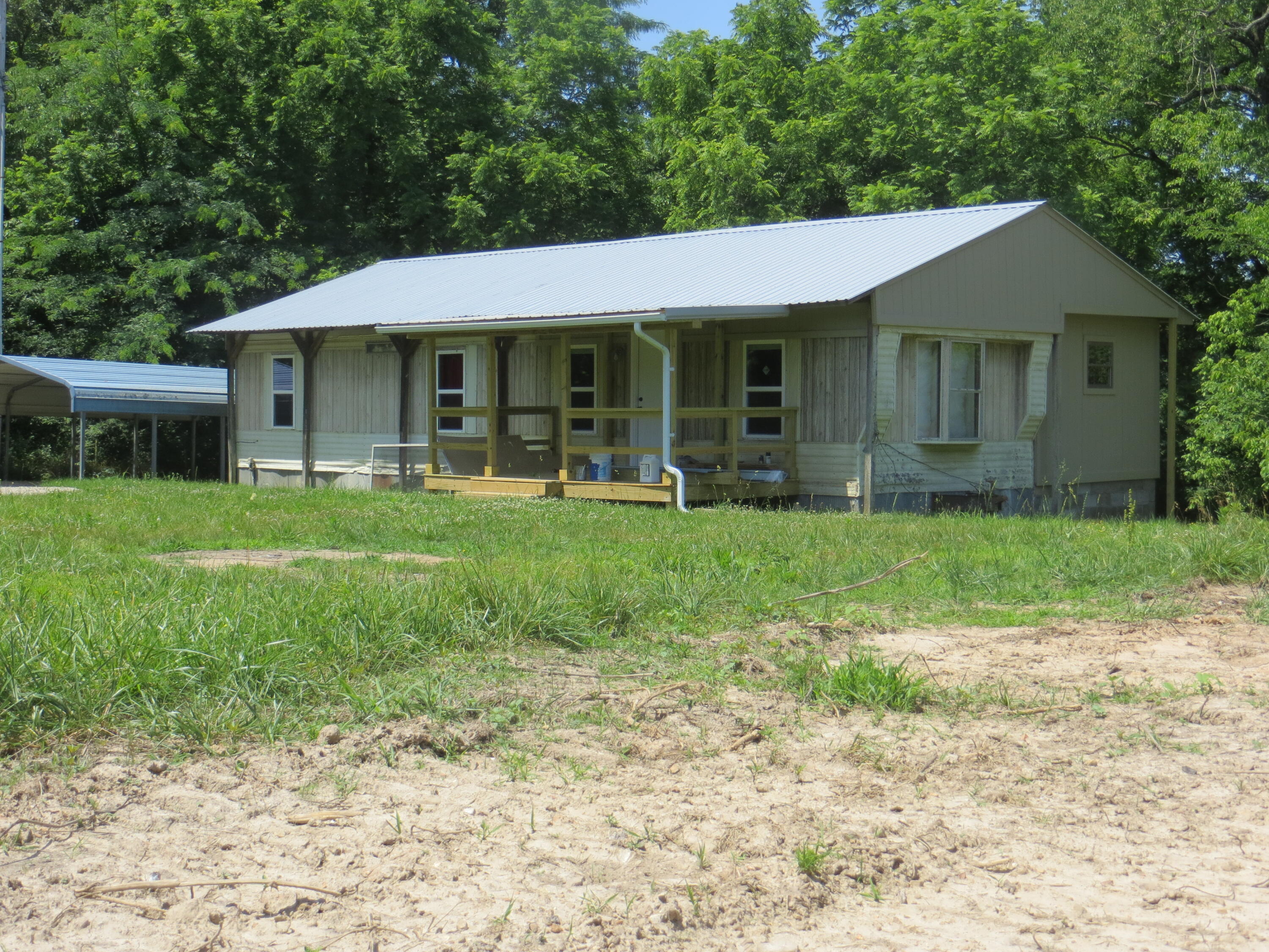 COUNTRY HOME/FARM/RECREATIONAL ... 26 acres at  road's end location for privacy. There's a good mixture of open and woods; various oaks and several walnut trees. The pond will be good for animals and wildlife, the land lays good level to gently rolling to some slopes. Ideal place to run a few animals, has some fencing. Home has 5 rooms, 3 bedrooms, 12x10 bathroom with washer/dryer hook-ups. Front and back porches provide a relaxing place to spend the evening. Home is half manufactured and half stick build. Very close to Warmfork River, neighbor might let you cross to it or its just over a mile to public access to Spring River for all kinds of fishing and boating. County road ends at property. You couldn't ask for more at only $154,900.
