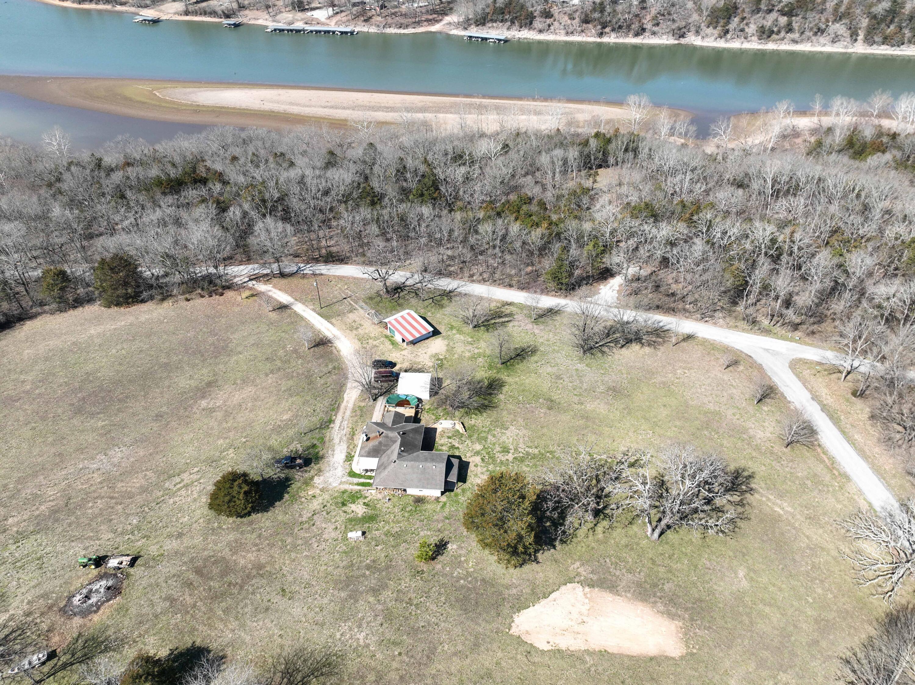 Adorable country home and acreage close to Table Rock Lake! This well appointed two bedroom, two bath home sits just above Table Rock Lake on 7.1 acres. Open kitchen, living , dining area offers a spacious feel, French Doors open to the 16 x 20 deck leading out to the above ground pool. Large pantry in the laundry room and beautiful oak cabinets in the kitchen allow for plenty of storage. All new windows and newer heat pump plus cozy wood stove will keep you toasty in the winter while you enjoy your winter lake view. In the summer, enjoy the pool or handy river access to stay cool. Private community boat launch nearby. Or enjoy your own recreation and relaxation on your mostly pastured 7 acres. Also has a 24 x 20 equipment shed for your toys or tools, Schedule your showing today to take advantage of all the possibilities!