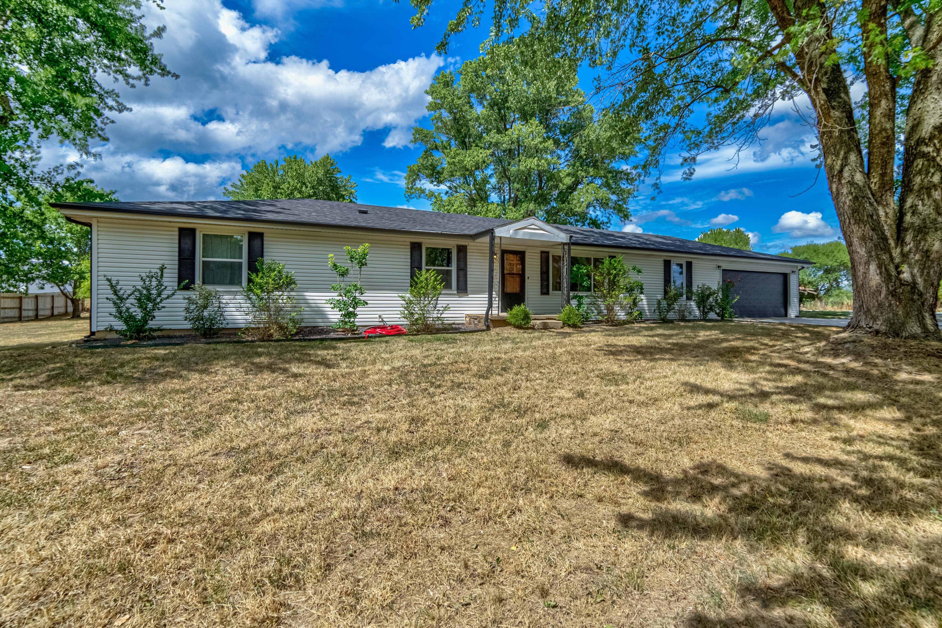 Country living with no restrictions! This 3 bed, 2 bath home sits on almost 9 acres of level pasture land just minutes from Bolivar. Step into the nice sized living room featuring wood floors and a large window. The bakers kitchen features a beautiful tiled backsplash and a large island with ample storage and seating for 6. Master bedroom includes an ensuite bathroom and walk-in closet. All bedrooms are sizeable and sure to please! Don't miss the spacious utility room and oversized garage large enough to add a second living space or a workshop! Step out back to the covered patio for morning coffee or peaceful sunset views. The large shop includes electricity and concrete floors, perfect for machinery or a large workshop. The old milk house/dog kennel has electricity and water. Mostly open and level pasture has woven wire fencing. Call and schedule your private showing today!