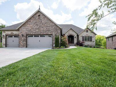 CUL DE SAC!!!   This all brick, perfect family home is located in south Springfield's Olde Ivy Subdivision; and is minutes away from shopping and restaurants, with easy access to both James River Expressway and Hwy 65.   Energy star rated home, custom built by a certified Green builder in 2011,  features a barrel ceiling in the entryway, open floor plan, crown molding, hickory floors, custom knotty alder cabinets,  granite countertops throughout, walk-out basement, 3 car over-sized garage, open floor plan, and large deep lot backing up to woods.  A portion of the backyard is fenced, but being so close to Springfield's Nature Center and backing up to the woods it definitely has a private feel even though you are in the city.  Don't be surprised if you see deer, turkey, or an occasional fox.   The floor plan is very family friendly with an open kitchen and large living room w/fireplace. The kitchen includes a gas stove and stainless-steel appliances. Set on the covered deck and enjoy the views! The home has a split floorplan with the primary suite being a highlight. The primary bathroom has a large walk-in shower with multiple shower heads, double sinks, and jet bathtub. The closet is super-sized.  The other side of the main level includes two bedrooms, bathroom and a large laundry room. Downstairs has a living space and a large granite wet bar with more cabinet storage, an office , another bedroom and bathroom. The John Deer room was carpeted and converted into an extra living space. The storage area is large and has a concrete storm shelter. Outside the French doors is a covered patio.   Don't miss this great home in a wonderful location.