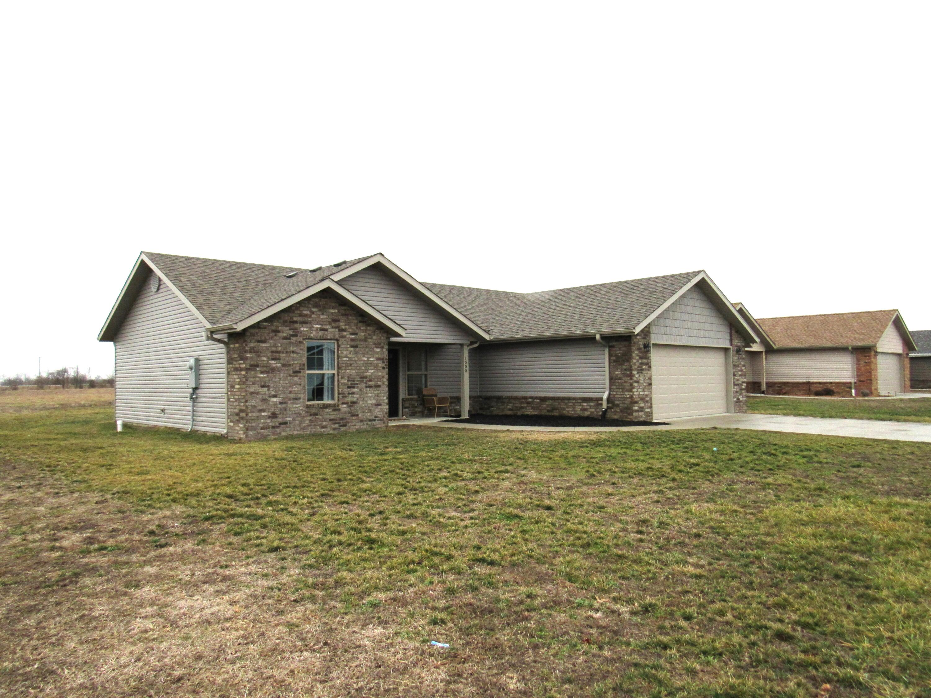 Your Lucky Day!  Owners are relocating so here is your chance to snag a like-new, 3 Bedroom, 2 Bath home in Bolivar that was built in 2021!   Sitting on a corner lot in Spring Crest Subdivision, the exterior of this great home is low maintenance brick and vinyl and has a covered front entry and covered back patio.  Inside you will find an open floor plan with living, kitchen and dining in heart of the home.   In the living room you will find a cozy electric fireplace that the owners are willing to leave with the home, but....it is not a permanent fixture and can be removed if preferred.  The kitchen boast lots of white cabinets with stunning granite countertops and stainless appliances, stove, microhood, dishwasher and refrigerator all included.  I love the gorgeous laminate flooring throughout the home but I thing the oversized pantry is my favorite amenity with space for a coffee bar, food and small appliance storage.   The  dining area opens to the covered back patio.  The split bedroom plan has the master bedroom just off of the dining area and the master bath includes a walk-in closet and step in shower.   Two additional bedrooms share the second bath with the laundry room and attached two car garage completing this home.   Convenient location to the south side business district of Bolivar and 13 Highway.   Call today for your personal tour!