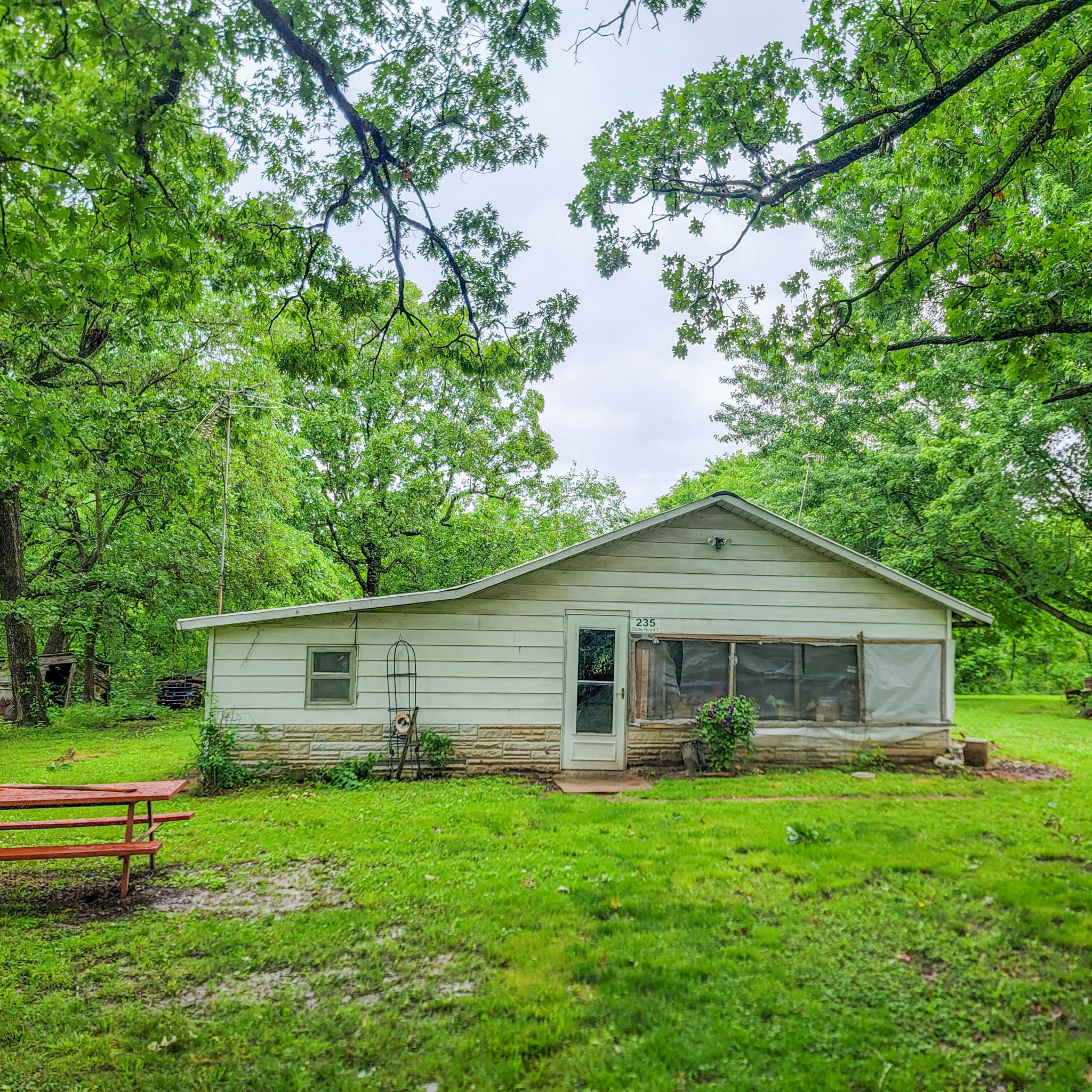 Older farm house sitting on 14.55 acres of beautiful Missouri acreage. This home has 2 Bedrooms, 1 bath and is in need of some major TLC. The acreage is pristine with big Missouri hard woods. The property also features 1500 feet of highway frontage and would be a great spot to build your dream home!