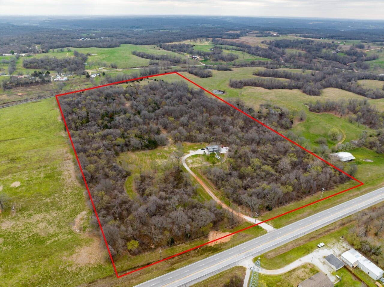 Unveil the potential of this extraordinary 39-acre gem nestled in the heart of Goodman, Missouri! Boasting prime frontage on a paved road and quick interstate access, this property is the epitome of convenience and wilderness.  This property invites you to embark on a journey of possibilities. Imagine a long driveway leading to your secluded oasis, complete with a well, septic, and electricity - all expertly installed in 2022. Beyond city limits, the landscape seamlessly transitions from dense woods to open clearings, catering to avid hunters. A colossal 44x50 Carolina Carport by Viking Steel stands proudly, accompanied by a crackling firepit. This is your chance to claim a slice of serenity conveniently located for anywhere in Southwest Missouri or Northwest Arkansas!