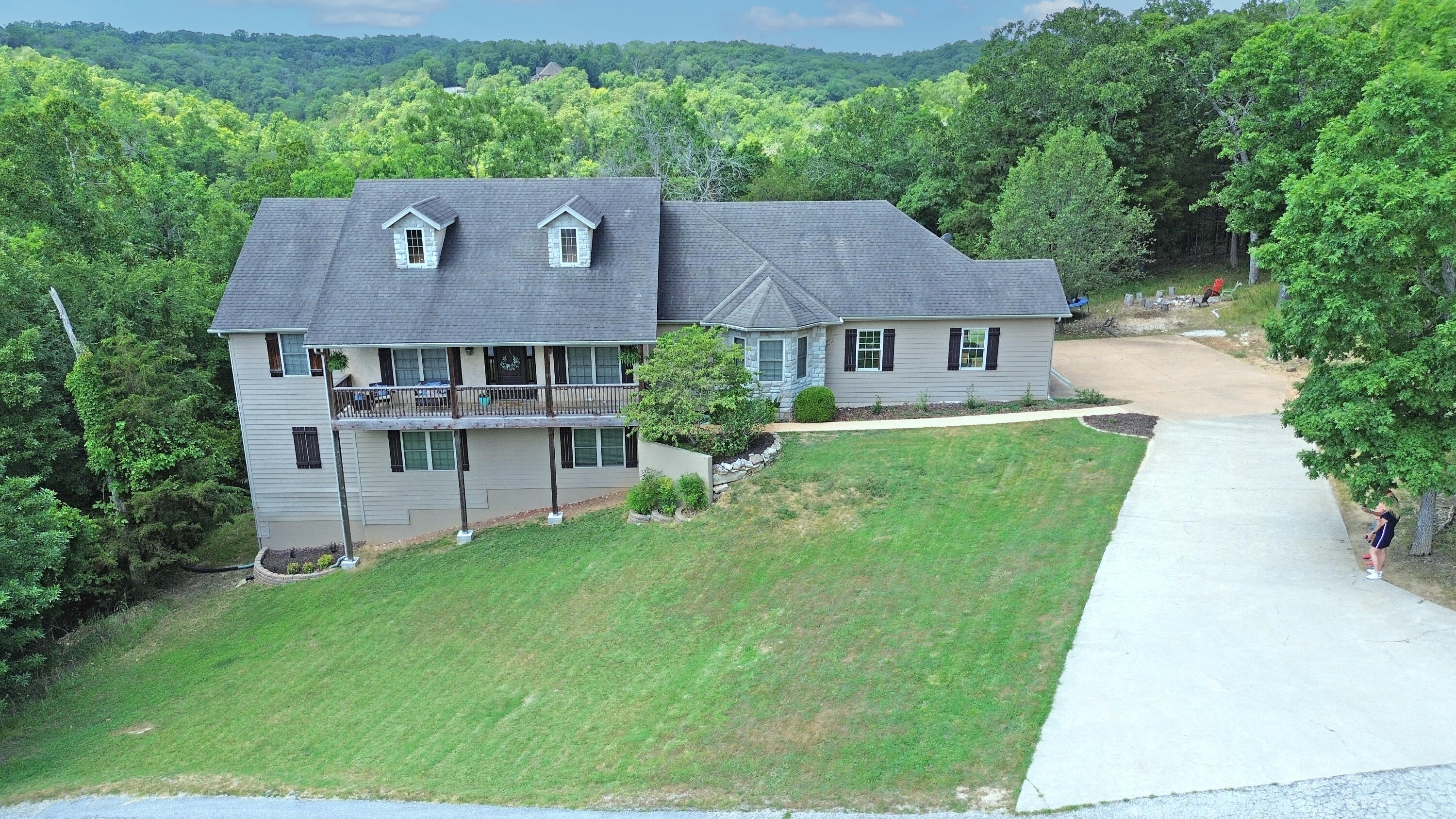Looking for privacy? This unique 7.5 Acre offering is surrounded by Native Ozark's forest that you share with white tail deer and wild turkey and can watch from one of your 5 outdoor living areas. Located in beautiful Cedar Meadows Subdivision, and only a short 15 minute drive to Branson's Entertainment and includes a path behind the house that goes to Lake Taneycomo. Features include spacious kitchen with granite counters, custom cupboards, and pecan floors. 2 bedrooms and master suite on main level with two baths and a separate living area in the lower level perfect for a mother-in-law quarters with large living room, kitchen, another master suite, 2 more bedrooms, and 2 more baths. Enjoy 2 fireplaces on those nippy Ozark's nights. We have virtually staged some of the photos to give you an idea of the endless possibilities this special offering provides.
