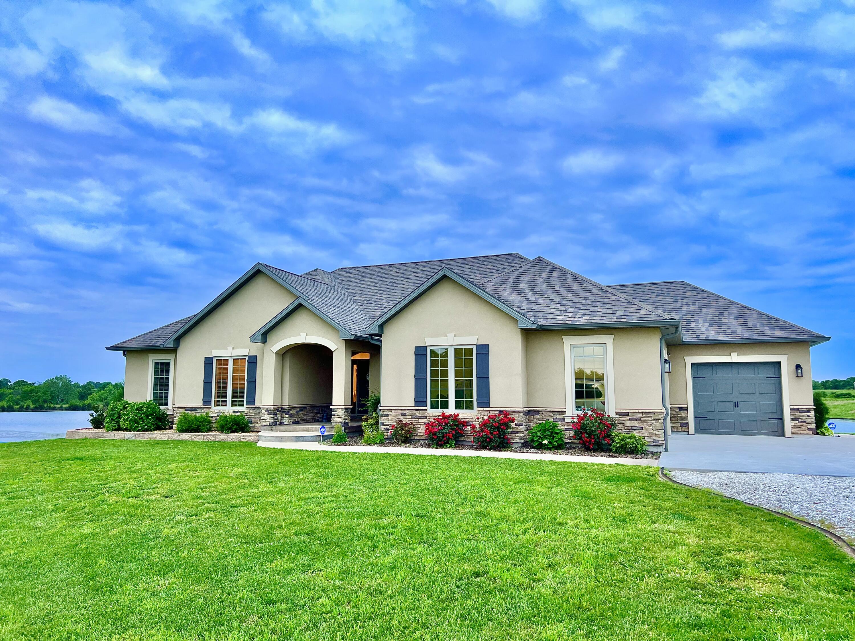 Here is a beautiful, very well maintained, 4 bedroom, 4 1/2 bath home! Built in 2017 this home sits in a quiet neighborhood just outside of city limits. Driving up to this home, you will notice the beauty of the outside and then an amazing view of the community pond behind it. You will never see any sunset like you will at this house! Walking to your front door all you can notice is the beautiful landscaping. As you walk thru the front door you walk into a large living area, with a beautiful gas fireplace. Your living room windows overlook the pond. This home has  amazing dining area, and a stunning kitchen with appliances that will stay with the sale of the home! This kitchen is anyone's dream with a giant walk in pantry, large beautiful cabinets, separate sink on its own island, and light fixtures and lighting that top it all off. There is also a half bath near the garage. Upstairs there is a large laundry room with a sink, one bedroom with its own bathroom and large closet. Also, your master bedroom is upstairs with its own bathroom!!  The master bedroom even has a office off of it, with a door outside to your back porch. The master bathroom is breath taking with a enormous shower and double sink area, then your master closet is even bigger! This home can be livable from just the top floor. Going down the beautiful staircase, you will have a finished basement.  There are 2 bedrooms down stairs, each have their own bathroom. Large living area with walk-out access, and has a small bar area with a sink. There is also a storm shelter, and a non conforming room that you can use for anything. Did I mention there is another room that has laundry hook ups down there?   Very well maintained 3 car garage. Also, community pond is stocked with fish. There is also a small fishing dock that comes with the home. This house has it all ! Pictures do not do justice ! Come see your yourself! You do not want to miss out on this home!