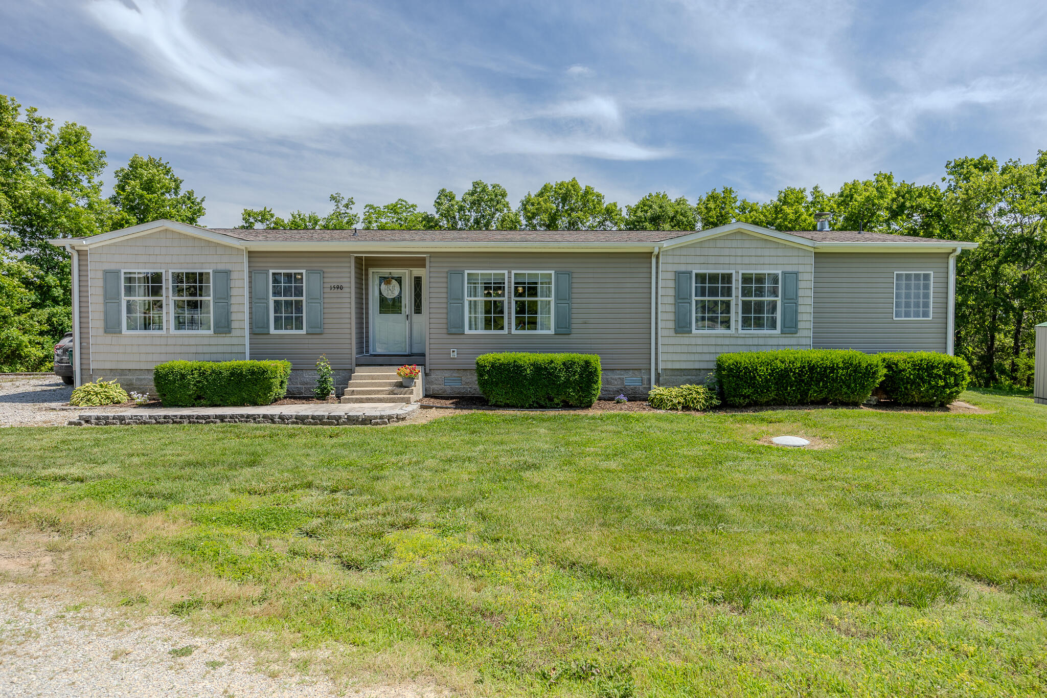 Beautiful 3 bed 2 bath home with a 30X50 shop just a mile from town on 3.9 acres. This large family home has a great open floor plan with laminate floors throughout the majority of the home. You will fall in love with the huge kitchen, island space for seating and a nice flow to the dining room and step down living room. The family room has plenty of windows for natural light and a wood burning fireplace. This home has a split bedroom plan with the master on one side of the home with a large walk in closet and on suite bath. The bath boasts his and her sinks along with a soaking tub and a walk in shower. On the other side of the home are bedrooms two and three which are both a great size with nice closet space. Don't miss the main bathroom that has double sinks, vinyl floors, linen storage and a tub/shower combo. The laundry room also serves as a mud room with some cabinets for storage along with a bench and place to hang coats. There is a nice large back deck, great landscaping, some woods for privacy and a 30X50 pole barn. The pole barn has a walk through door along with a double door for equipment, gravel floor and separate power. Don't miss out on this small acreage oasis perfect for hobby farming with a peaceful private setting!