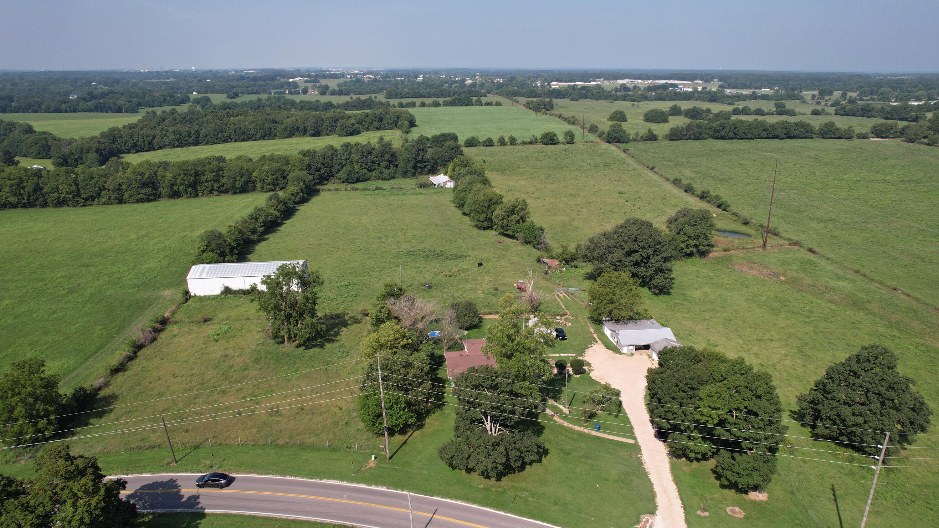 Attention investors, developers or farm buyers! This 80 ac. m/l Century Farm property has never been offered for sale but now it can be yours. It's located just 5/8's mile south of Old 66 (Hwy OO) at 125 & across from Cimarron Estates to the NE. Do you have a vision for a future farm, residence(s) or commercial operation w/rezoning? It has roughly 50 acres of brome hay ground just harvested & some deer woods on the west 40 acres. There's a nice 40'X100' pole barn for hay storage & a livestock barn in the valley. Imagine a mini 'The Greens of Springfield' in Strafford w/a 9 hole golf links course & affordable 55+ condos overlooking this beautiful rolling land on the seasonal waterway of Pearson Creek headwaters that meanders through the middle. Sanitary sewer is just north in the industrial park near the city limits, & there are 2 deep wells on the property. MoDot has been contacted about additional access for this land off Hwy 125 & the seller has offered to deed the 1/2 acre M/L east side part of the Hwy frontage included in the 80 acres to them to straighten out 125 through the curves. Presently they have no plans to invest in this necessary upgrade, but the right investor could expedite the process & it would be advantageous to them for safety reasons to make a deal. Farm or ranch facilities would not require any additional access, leaving it just as Smith Angus Farm has operated for over 100 years. The older home & barns are offered 'as is' by the absentee owner & tenant privileges require an appointment to view those. Some cattle are on the land & are gated so care must be taken to secure them. Call us today to set up your visit, as this property is priced to sell - it won't last long!