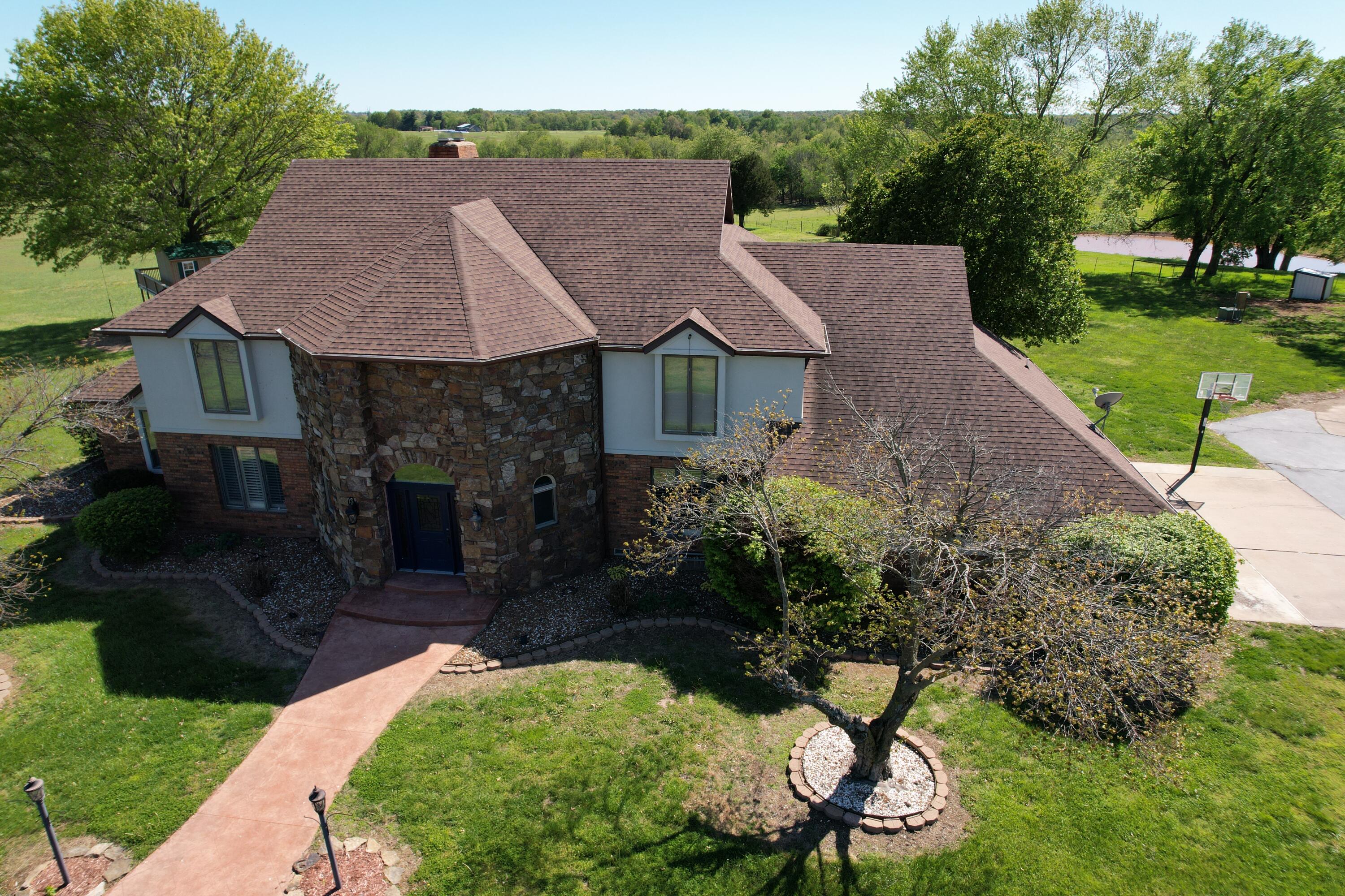 Stunning Tudor style home on 7.49 acres! Step into the Grand entryway and experience Cathedral ceilings, a beautiful staircase, living room with a wall of windows providing a view of the in-ground pool. This 4 BR, 3 BA home offers a 2-car attached garage, 2-car de-tached garage/shop, partial finished basement. Plantation shutters through-out. The primary on-suite is on the main level and includes a gas-log F/P, slate tile walk-in shower, sauna, jetted tub & walk-in closet. The upper level includes a landing overlooking the living room with floor to ceiling fireplace below. Jack N Jill bedrooms w/on-suite on one side with the 4th BR on-suite and walk-in closet on the other. Upper level bonus room could be used as a playroom, hobby room, home gym, office, or extra storage. The kitchen is great for entertaining with an island and wet bar. Enjoy the sunroom right off the kitchen area. Office on main level could be used as a non-conforming 5th BR. The partial finished basement is a great space for the whole family or the ever popular ''man cave''. The garage/shop includes a lean-to, 220 electric, and new LED lighting. RV hook-up is also available. Waterer on South side of property. New well pump w/new electrical in March/2023. HVAC only 3 yrs old. Newer appliances, freshly painted kitchen cabinets, new paint in several rooms. This home has been well-maintained with so much to offer!