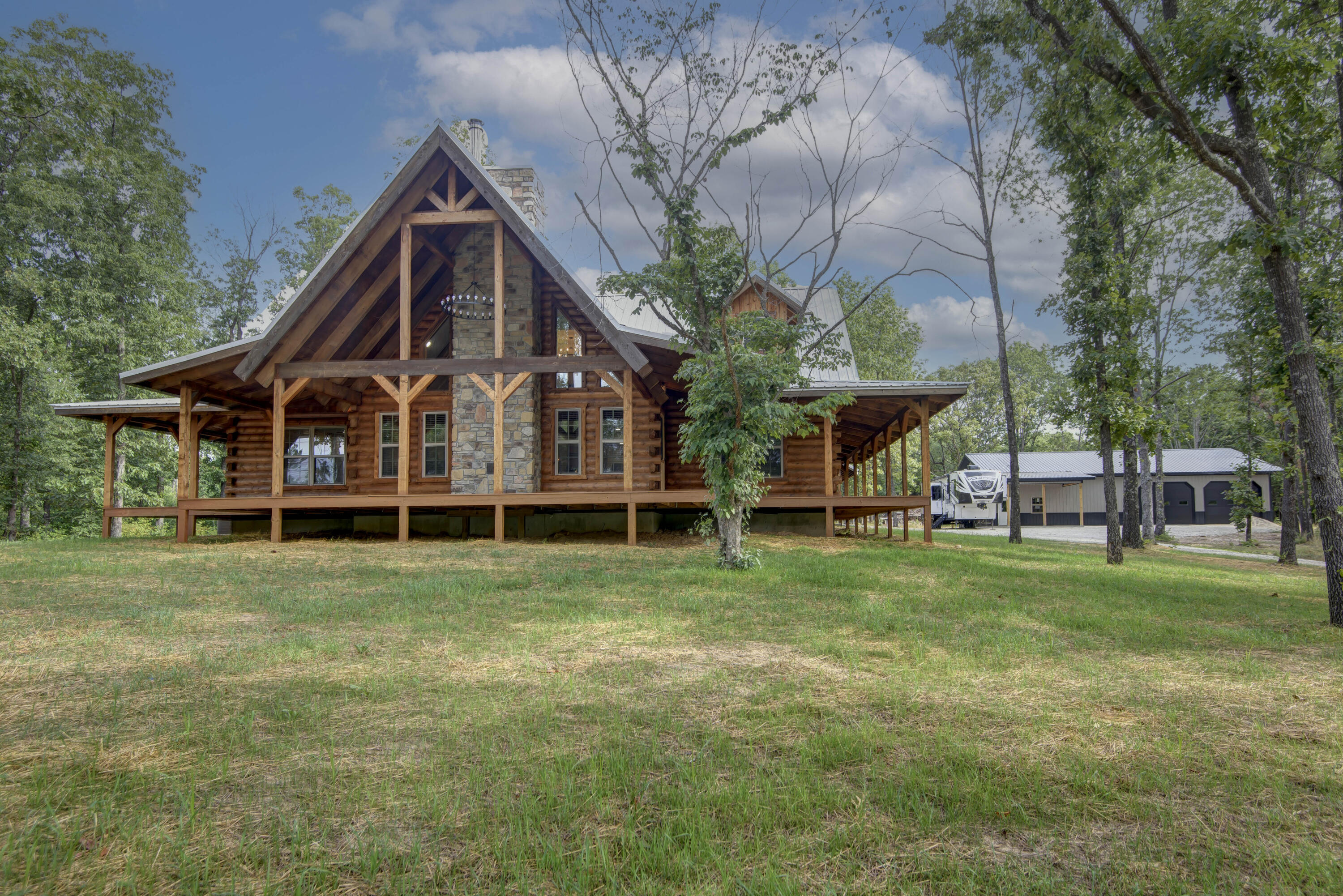 If you have ever dreamed of living in a log house in the woods now is your chance... 4 bedroom 4 bath story and a half custom built home. Over 2400 sq. feet of living area and a total of 4500 sq. feet under roof. Granite countertops - center island - cathedral ceiling in living area - wood burning stove - wrap around porch - New 40 x 60 shop with 2 12 foot black overhead doors - 12 x 60 lean too and even loft storage area... All nestled on 10 wooded acres and yes even a small spring fed pond...  Just a couple of miles out of town and only 30 short minutes to Springfield.