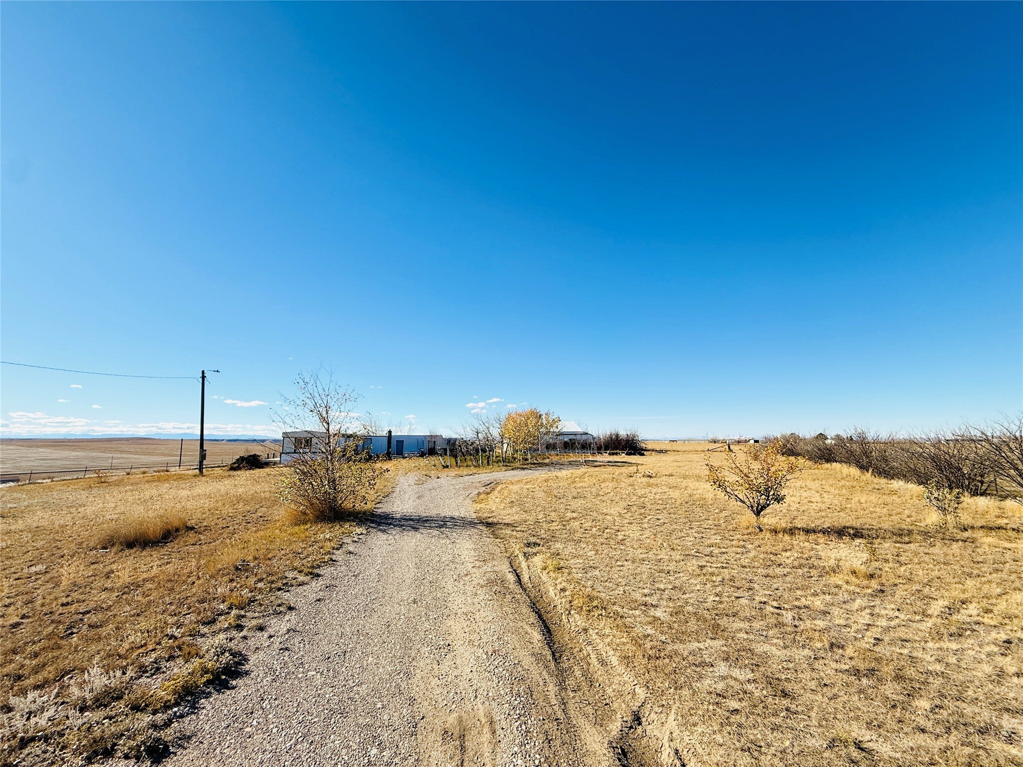 View of dirt / gravel road with a rural view