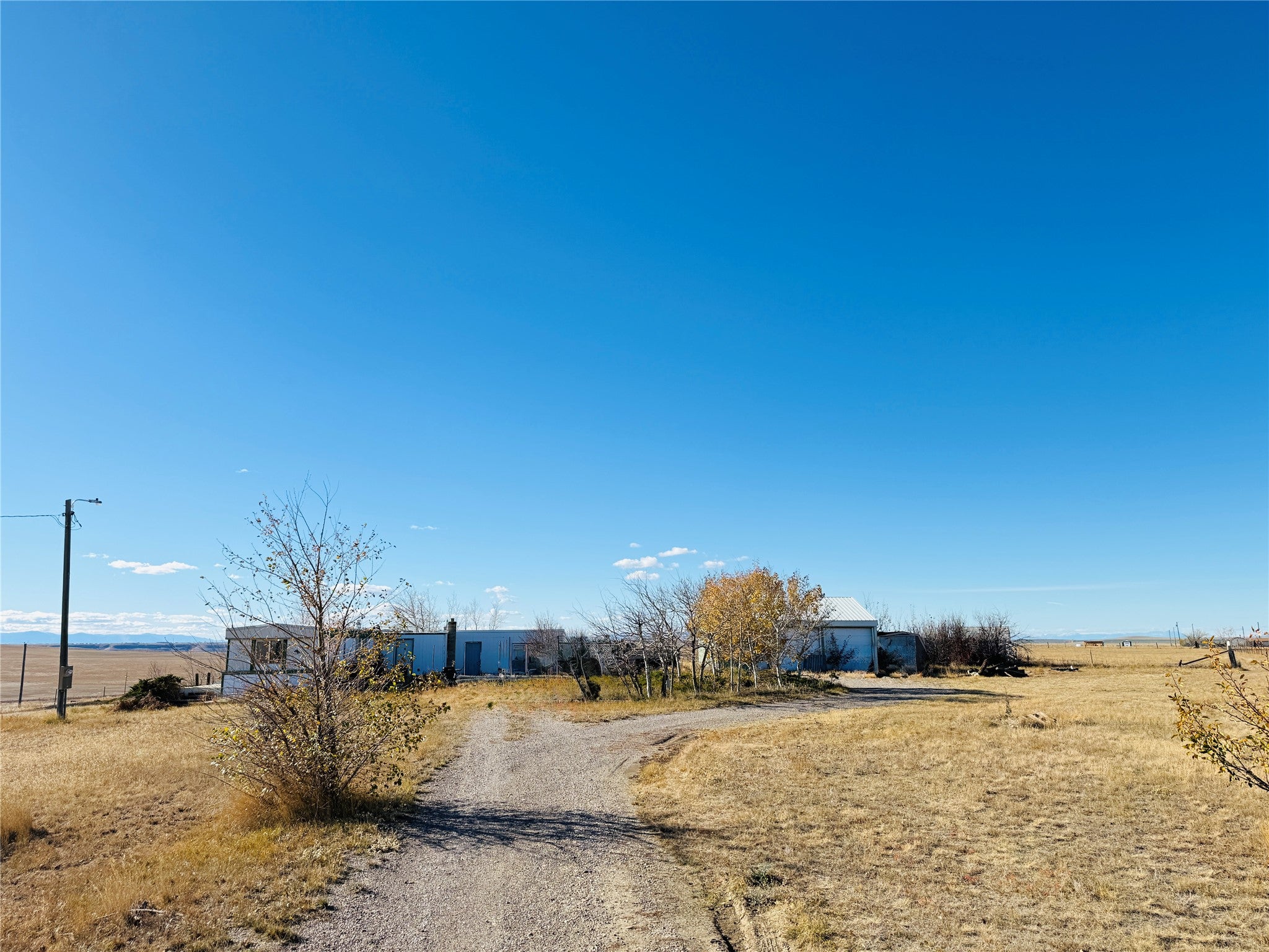 View of dirt / gravel road with a view of rural / pastoral area