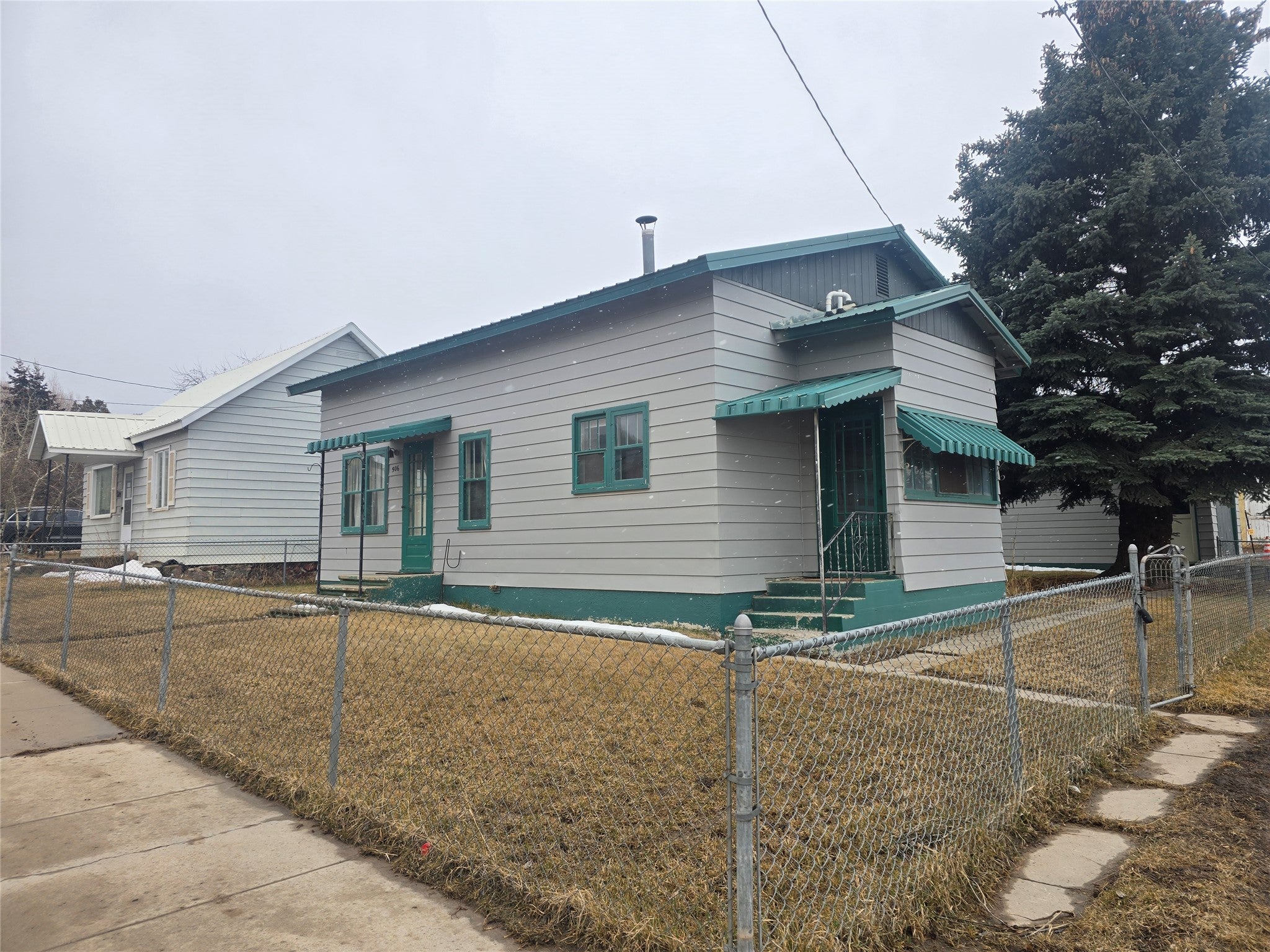 Bungalow-style house featuring a fenced front yard and entry steps