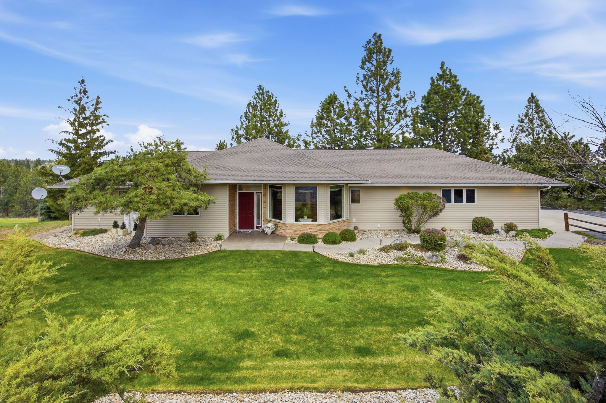 Ranch-style residence featuring a prominent bay window and a striking red entry door