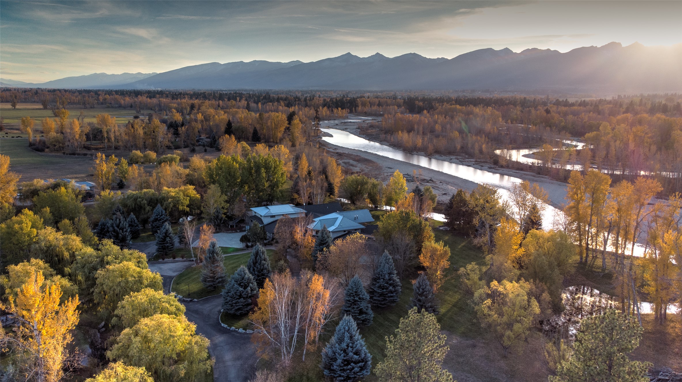 Aerial view of Bitterroot River running through property and Bitterroot Mountains at sunset