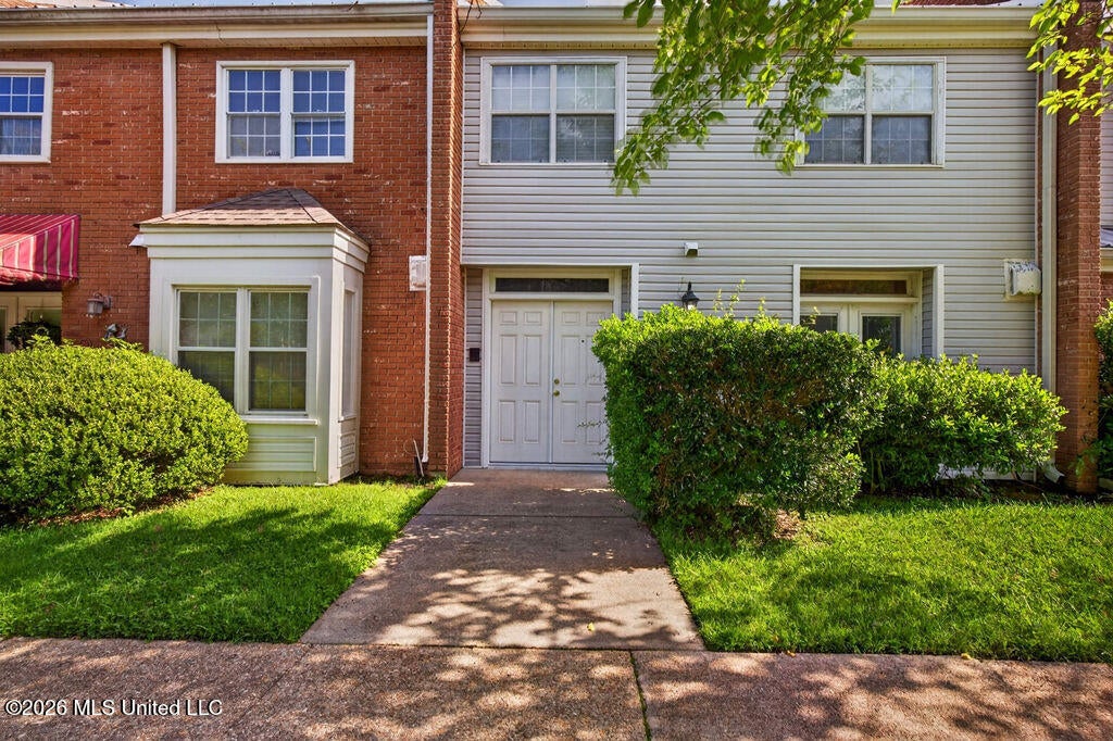 Front exterior view of Unit 22 with landscaped walkway and townhome-style entry.