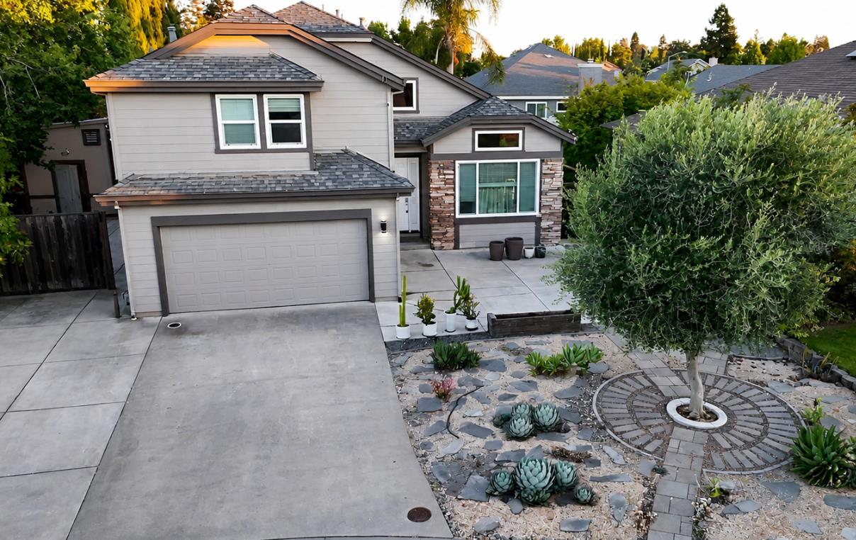 Two-story exterior with stone veneer accents, an attached garage, and a concrete driveway