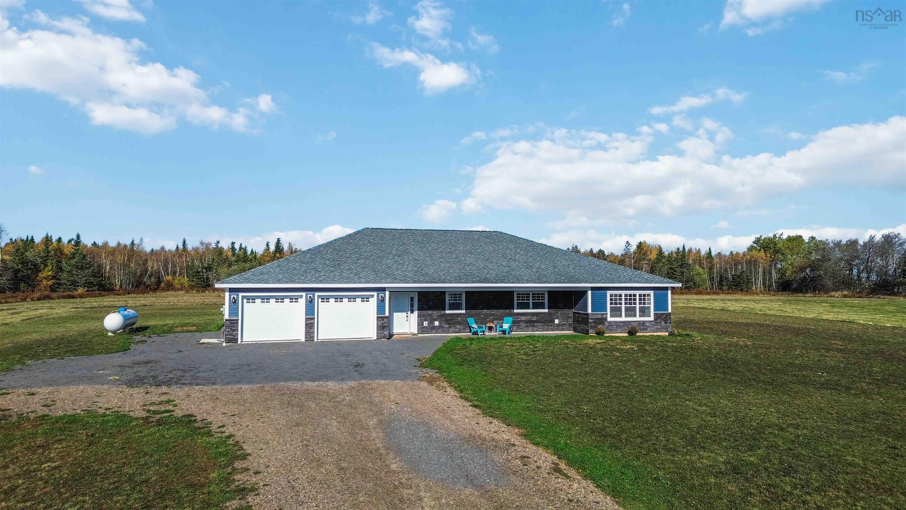 The property features a blue exterior with stone accents, a dark-colored roof, and a gravel driveway