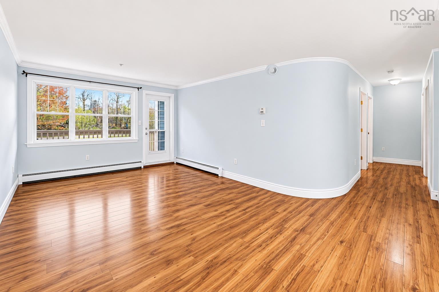 Open concept living area featuring wood-finish flooring, light blue walls, and white trim