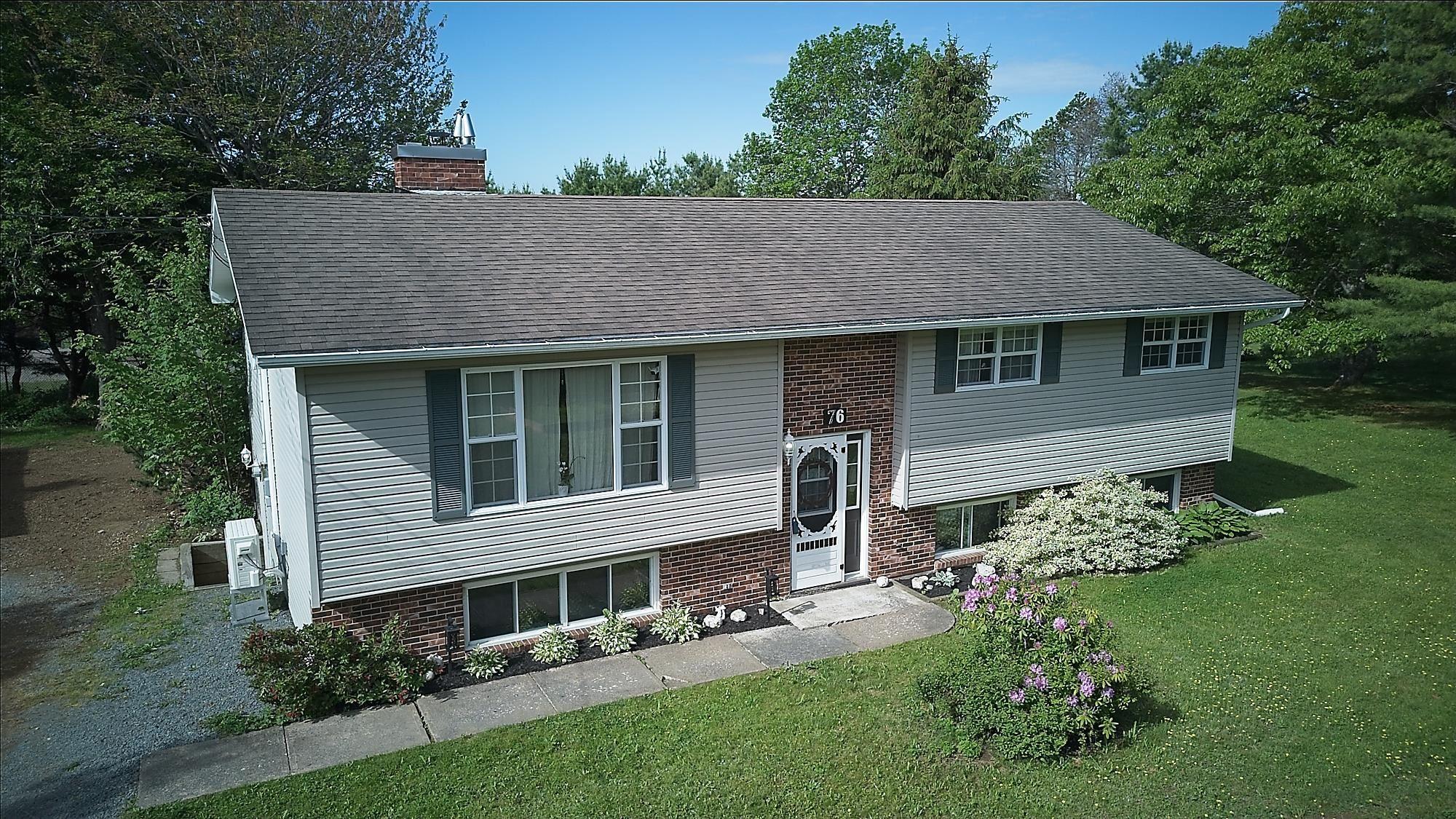 Split-level residence featuring light-colored siding and brick accents