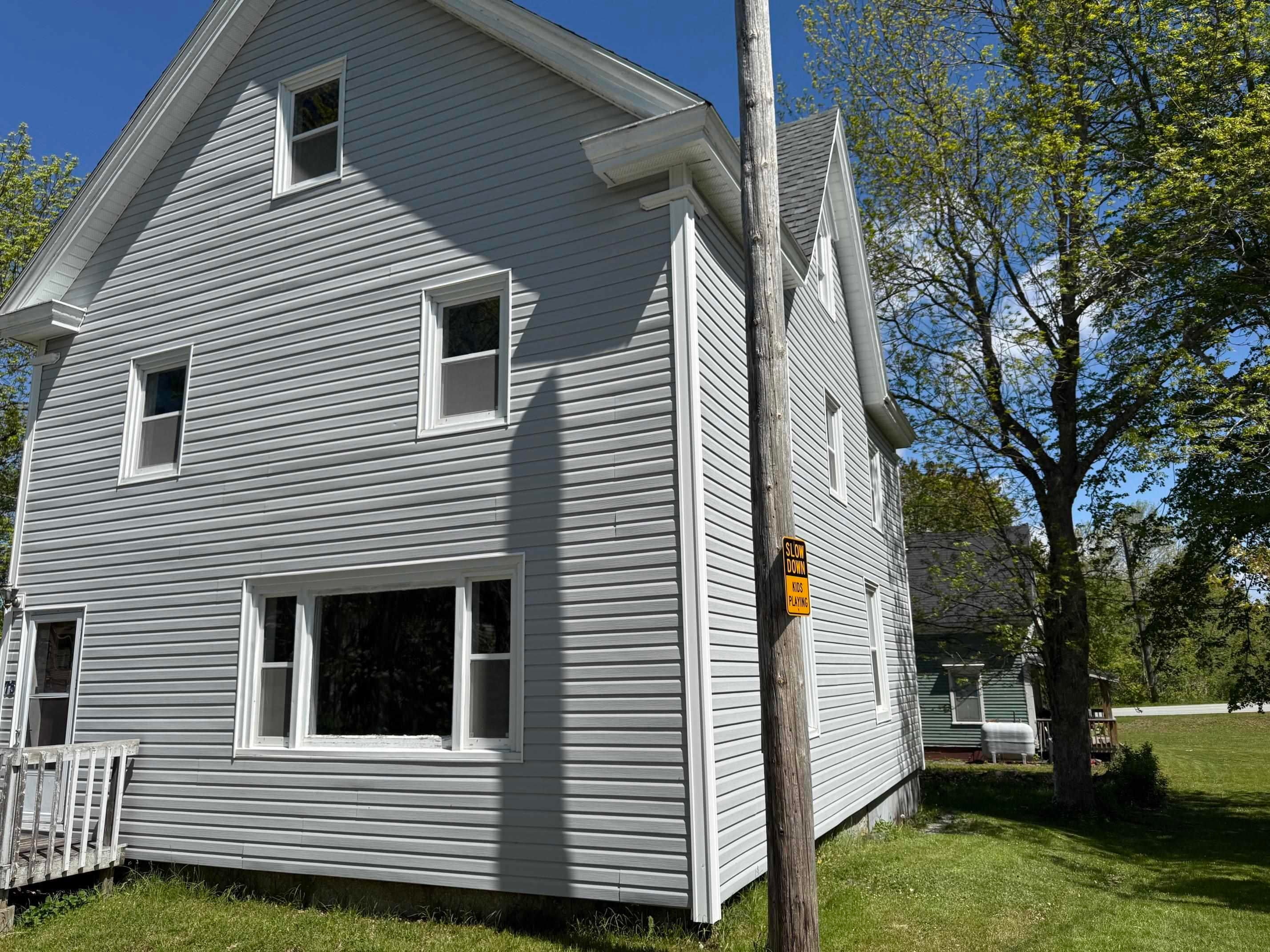Two-story residence featuring light gray vinyl siding and white trim