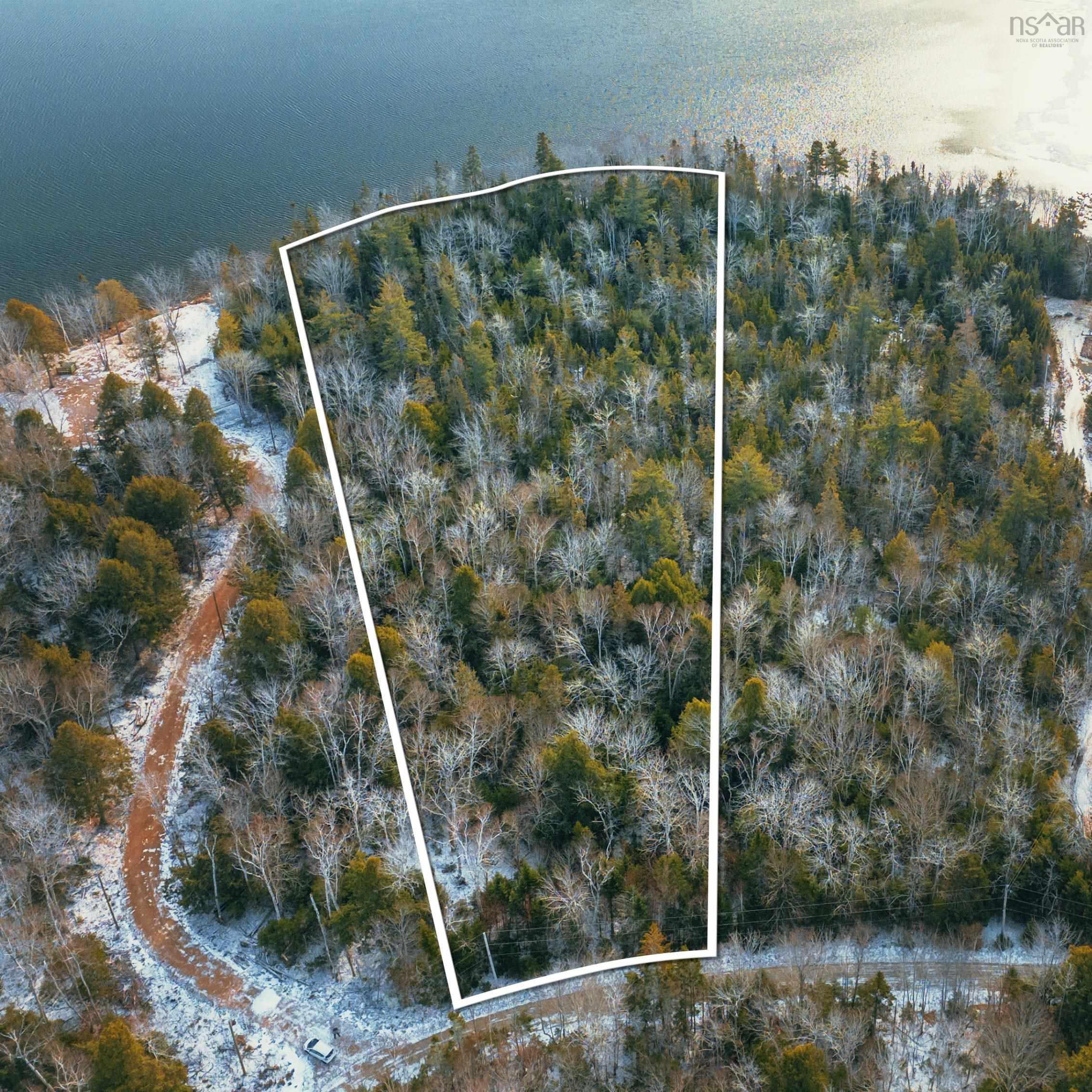 Aerial view of property and surrounding area featuring property boundaries highlighted and a nearby body of water