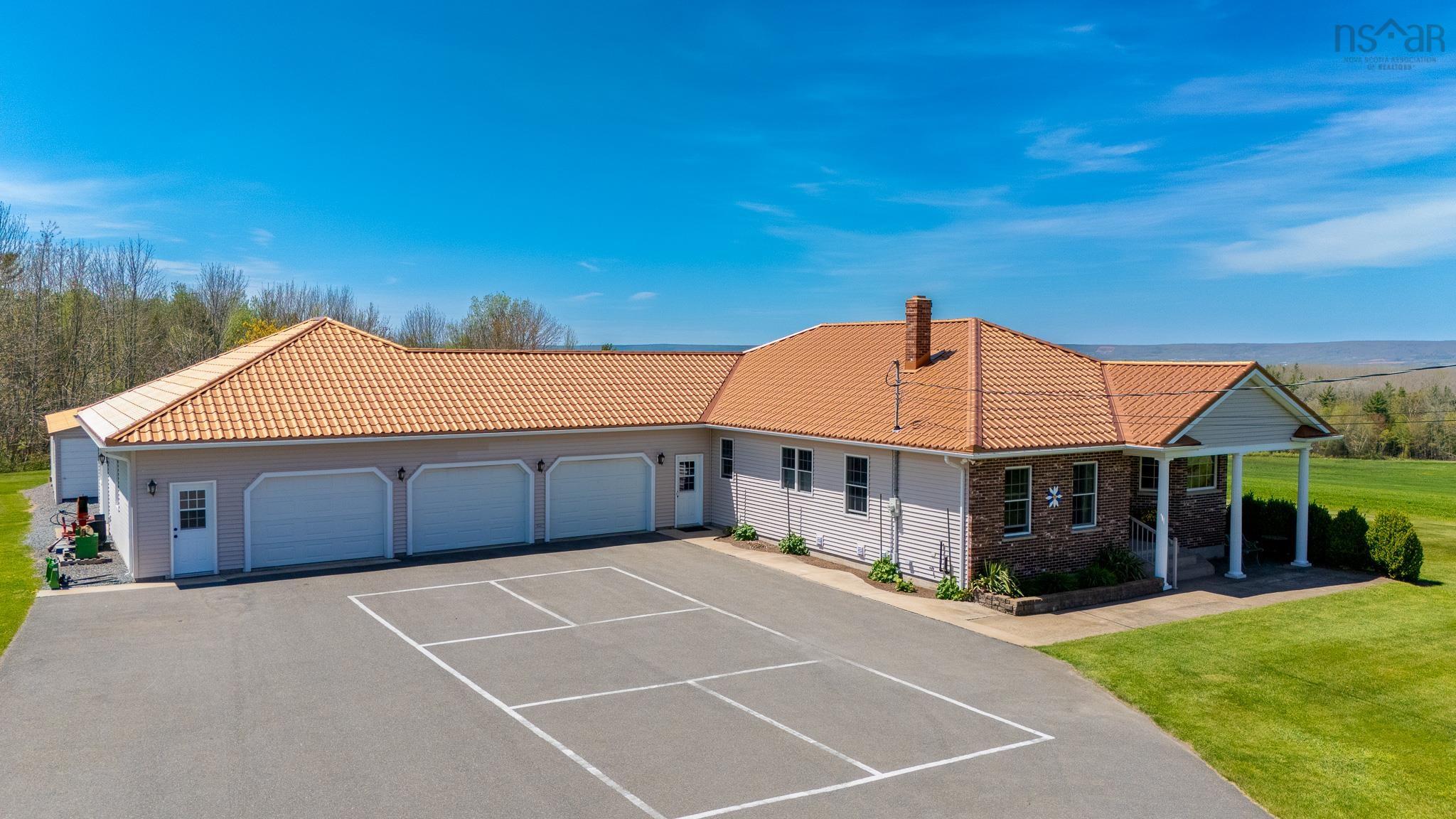 View of front of home with a tile roof, a chimney, an attached garage, and a front lawn
