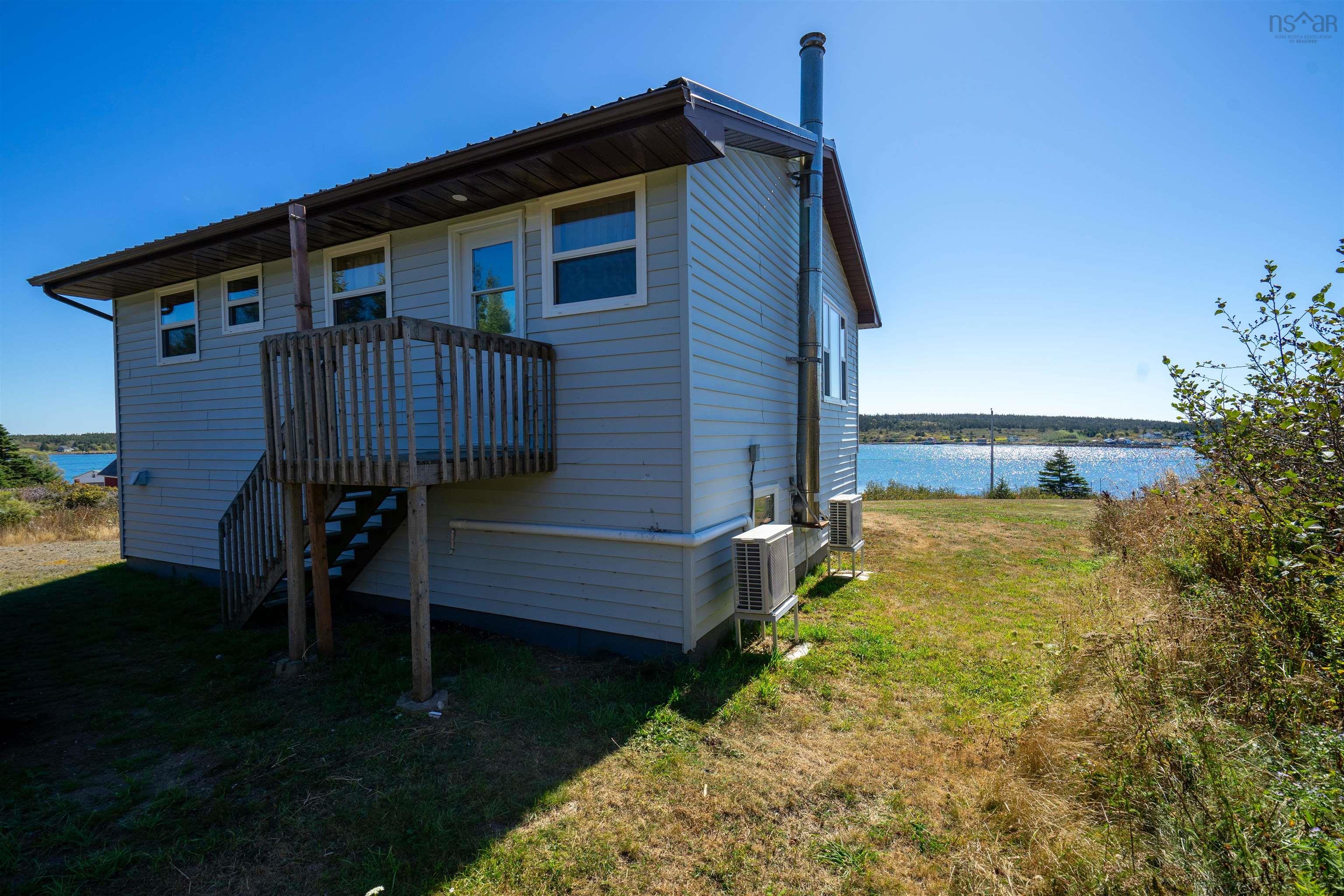 Back of property with a yard, a water view, and stairway