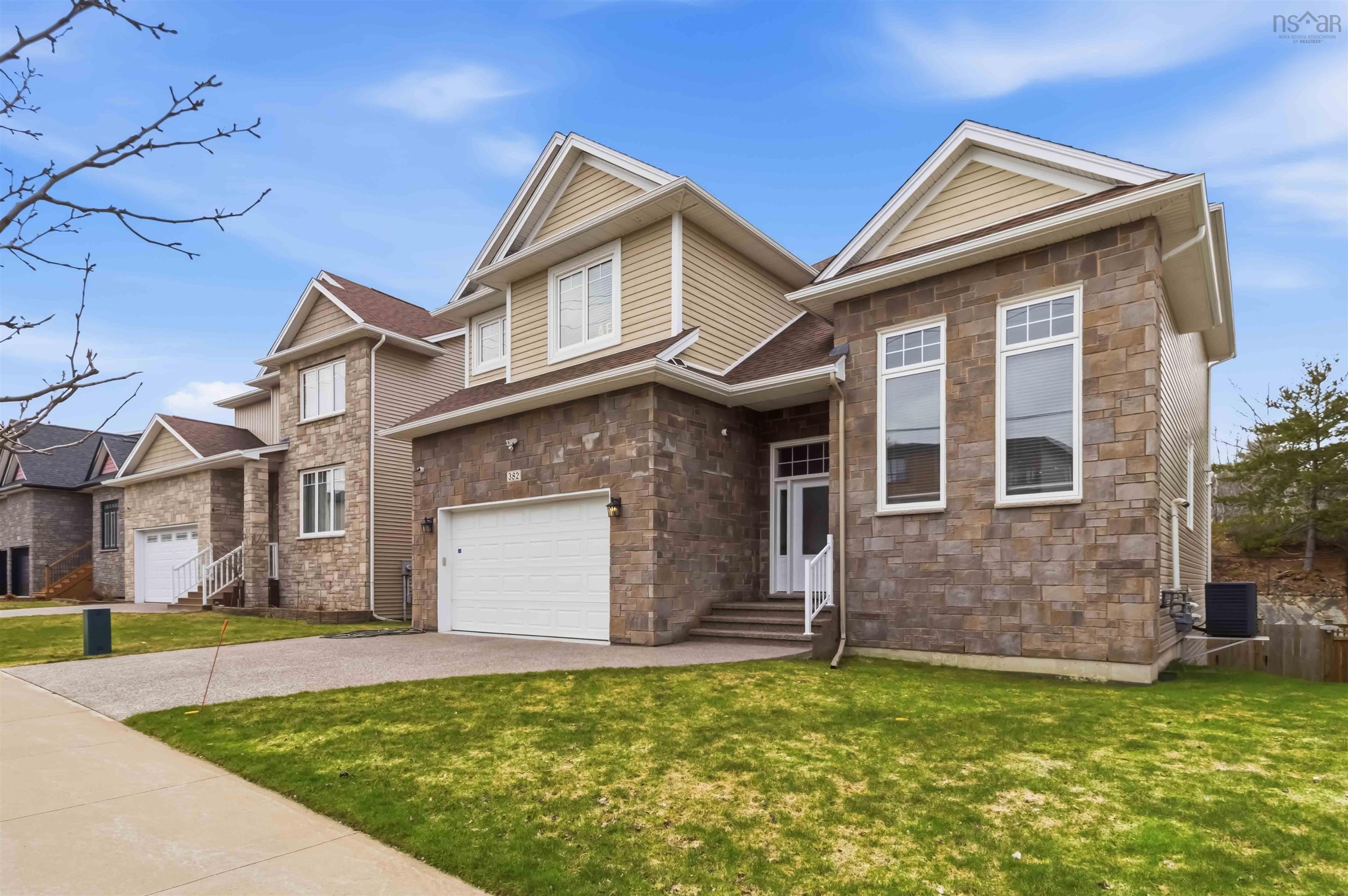 Contemporary stone and siding exterior with a prominent two-car garage